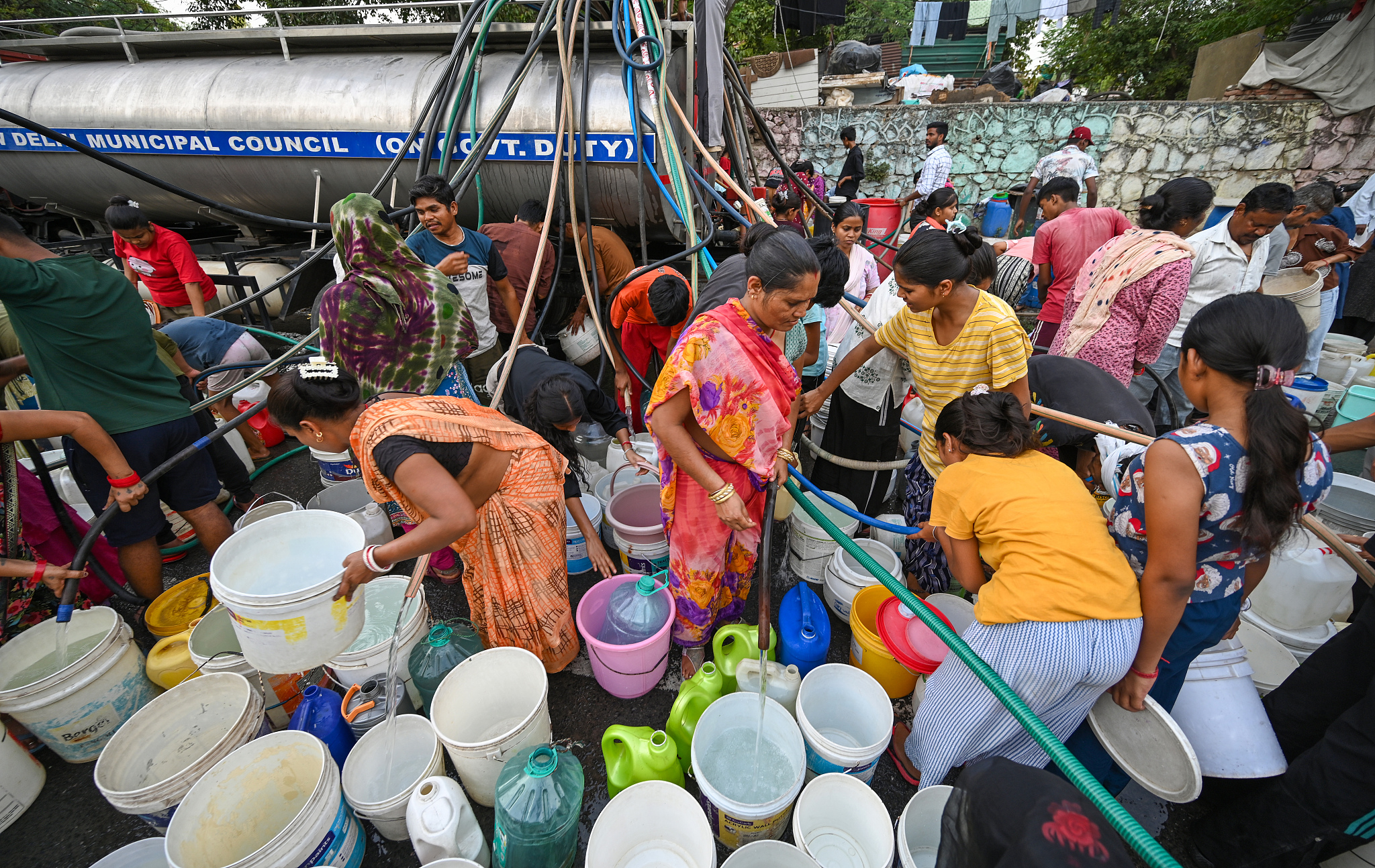 Residents of Sanjay Camp cluster around a Delhi Jal Board tanker to fill empty containers and buckets in New Delhi, India, May 25, 2026. /VCG
