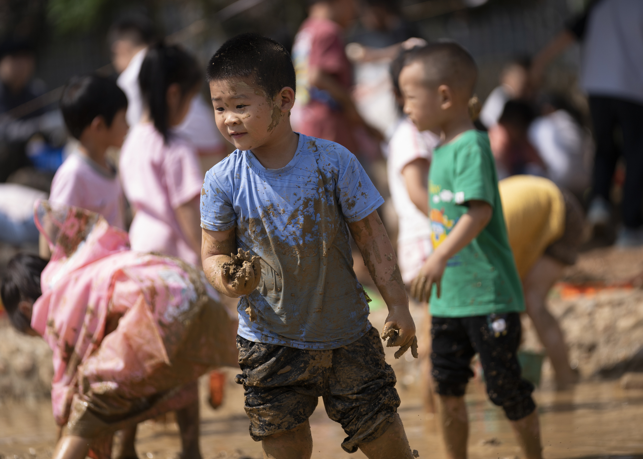 Children from a kindergarten in Xinyu City, east China's Jiangxi Province, play with mud as part of their Children's Day activities. /VCG