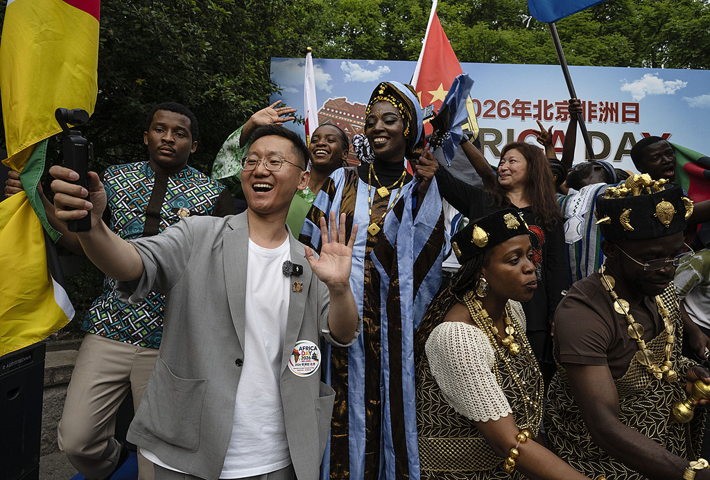 A Chinese visitor films a video while people from African countries participating in the Africa Day event in Beijing, China, May 23, 2026. /VCG