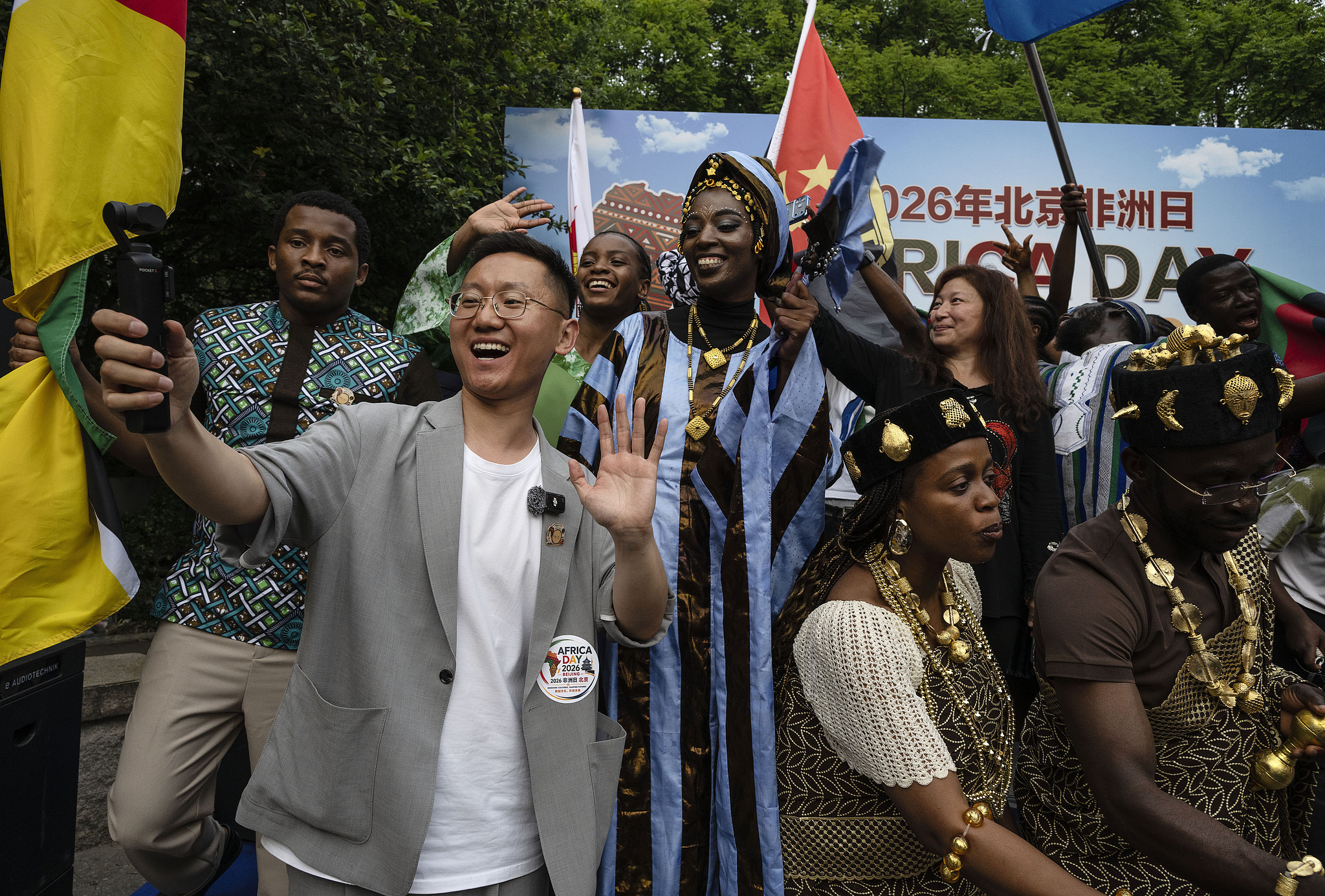 A Chinese visitor takes a video of himself as people from different African countries stand on the stage as they take part in Africa Day 2026, Beijing, China, May 23, 2026. /VCG