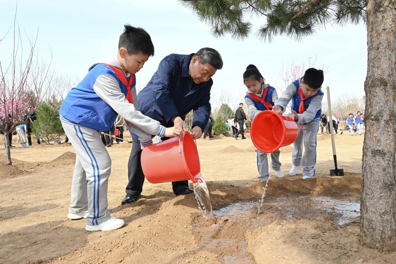 Chinese President Xi Jinping waters a tree with children during a voluntary tree-planting activity in Fengtai District in Beijing, China, April 3, 2025. /Xinhua