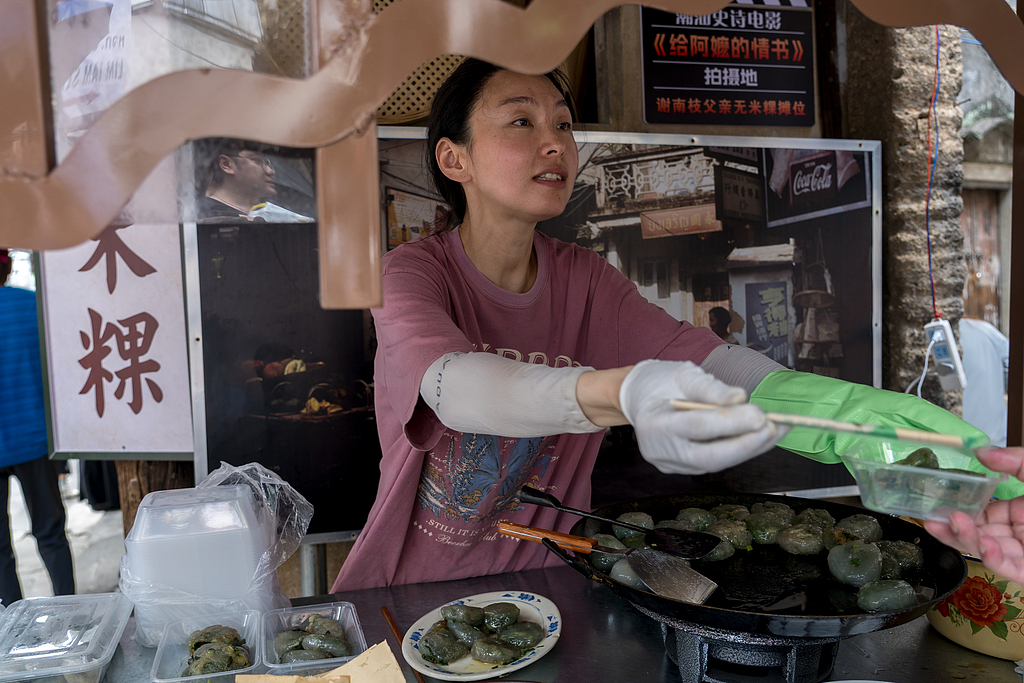 A woman sells dishes featured in the film Dear You from a recreated food stall in Mianhu Town in Jiexi County, Jieyang, Guangdong Province on May 31, 2026. /VCG