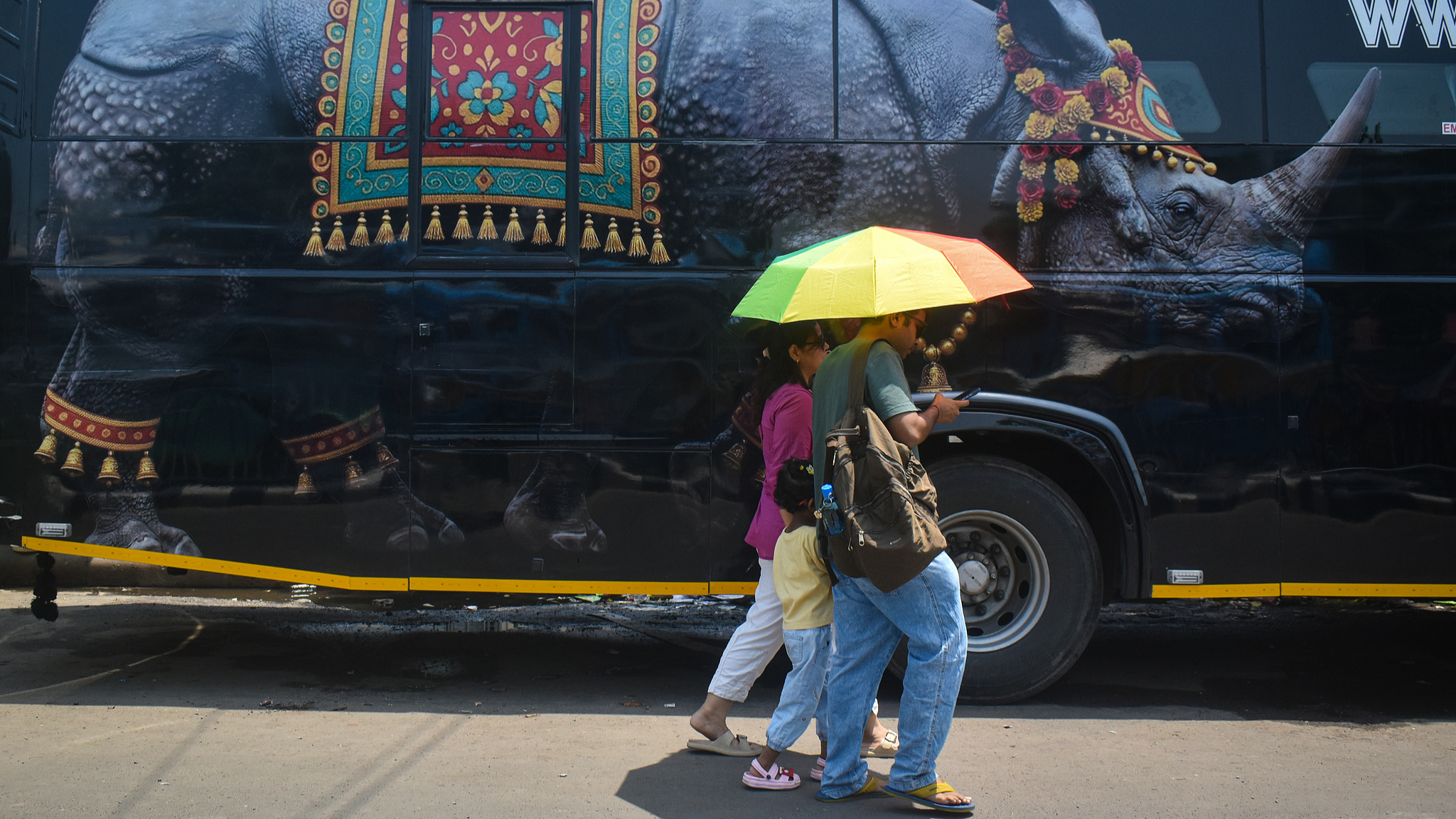 People seek the shade of umbrellas as they walk down the street on a hot summer day in Kolkata, India, May 31, 2026. /VCG