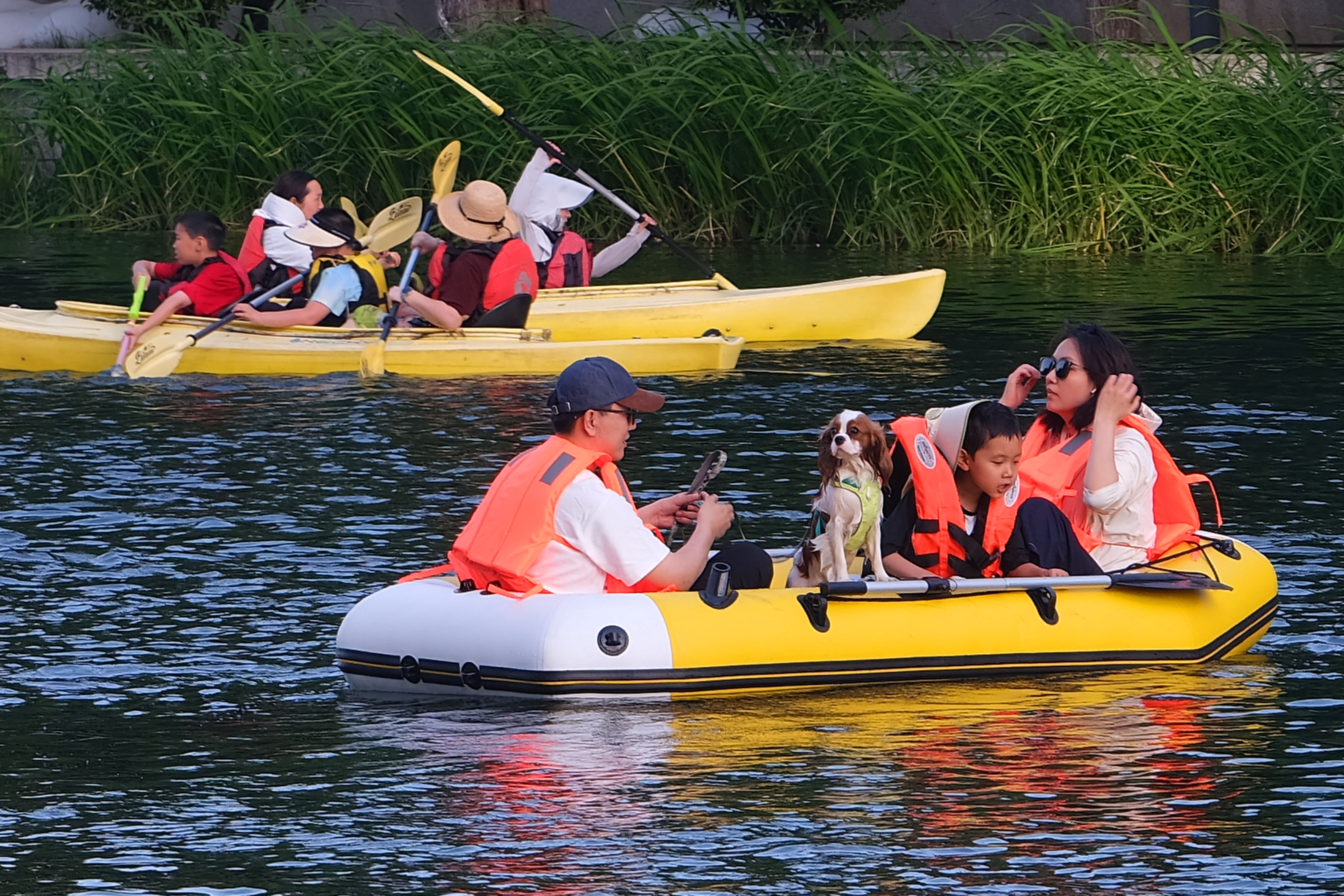 People paddle, kayak and relax along the Liangma River International Waterfront, a popular summer leisure destination in Beijing, on June 1, 2026. /IC