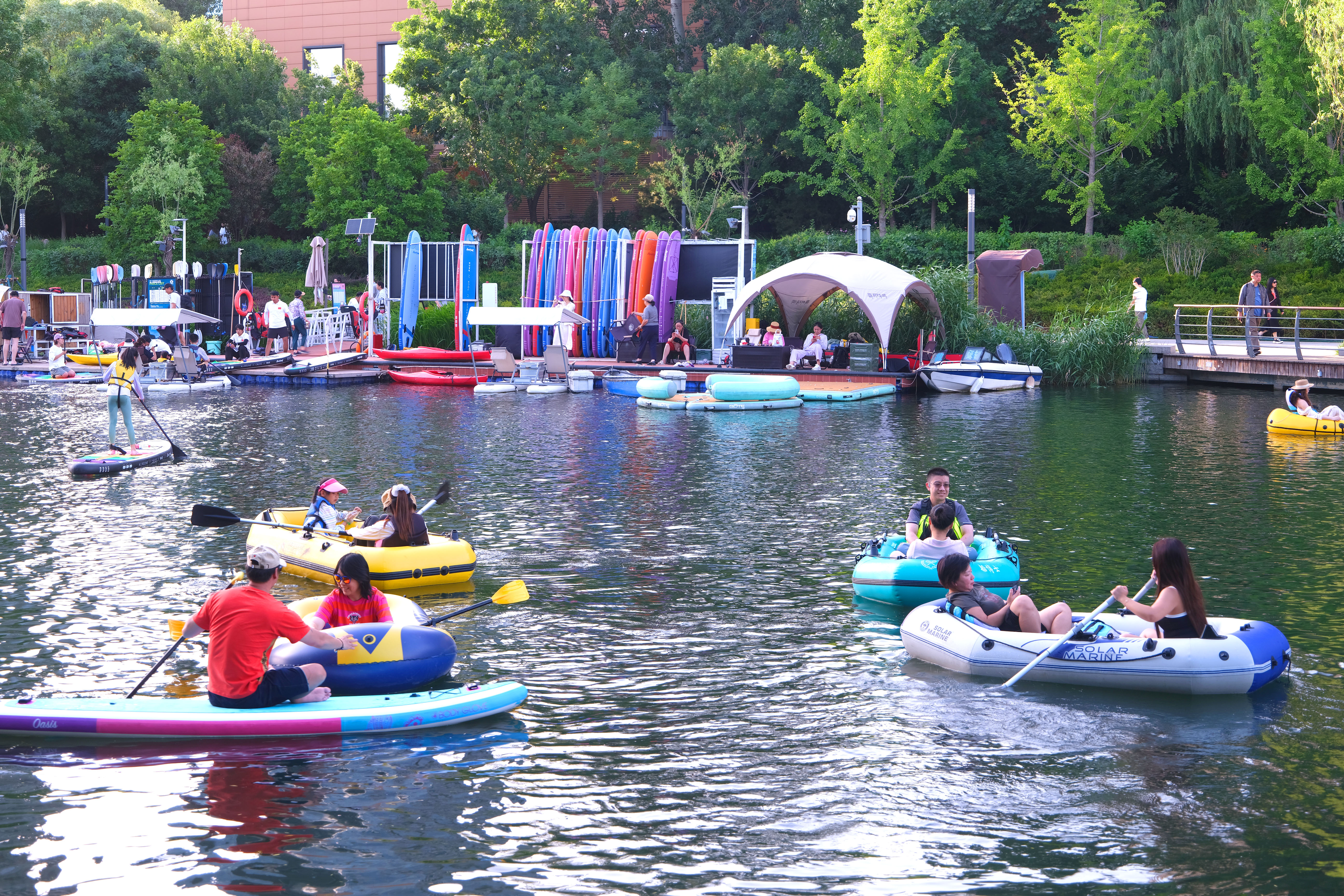 People paddle, kayak and relax along the Liangma River International Waterfront, a popular summer leisure destination in Beijing, on June 1, 2026. /IC