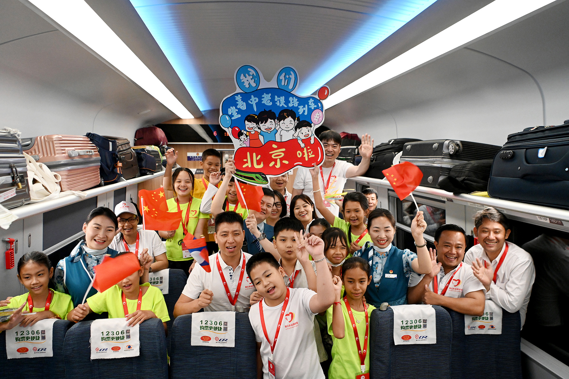 Lao students pose for photos aboard a China-Laos Railway train during their visit to China on May 25, 2023. /VCG