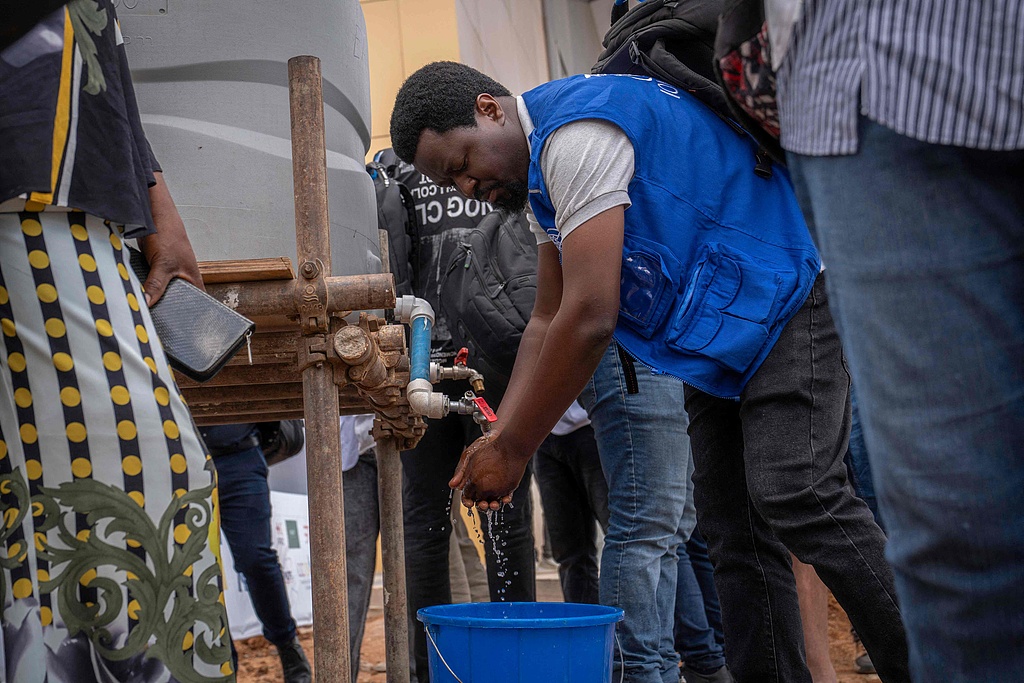 A passenger washes his hands at Bunia Airport, Democratic Republic of the Congo, June 3, 2026. /VCG