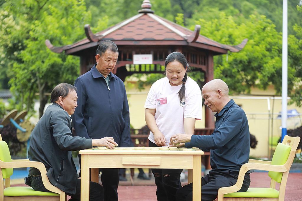 Volunteers play Chinese chess with elderly residents at an apartment for seniors in Guizhou Province, China, June 2, 2026. /VCG 