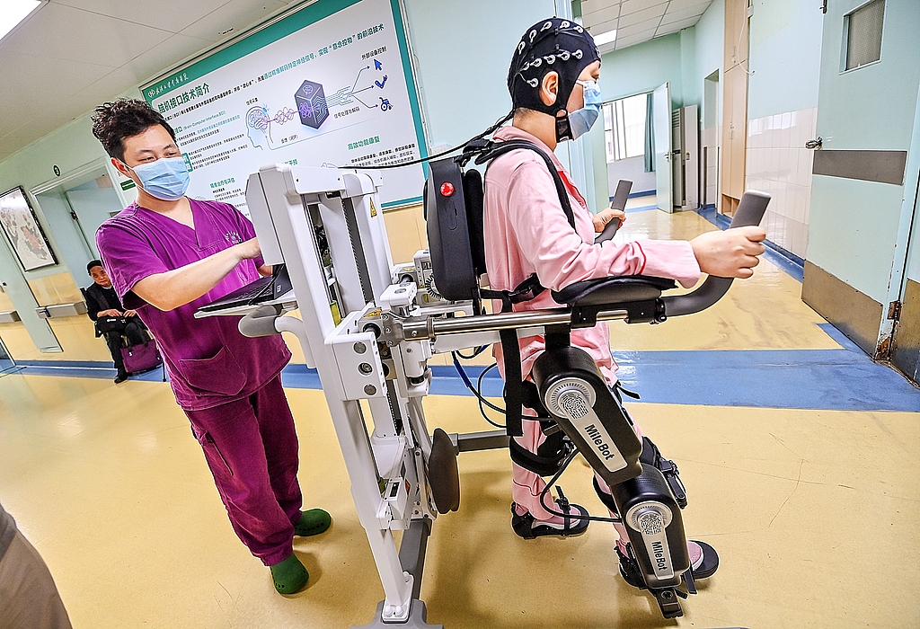 A patient wears an EEG cap and uses brain signals to control a robotic device for walking, Wuhan, central China's Hubei Province, May 19, 2026. /VCG