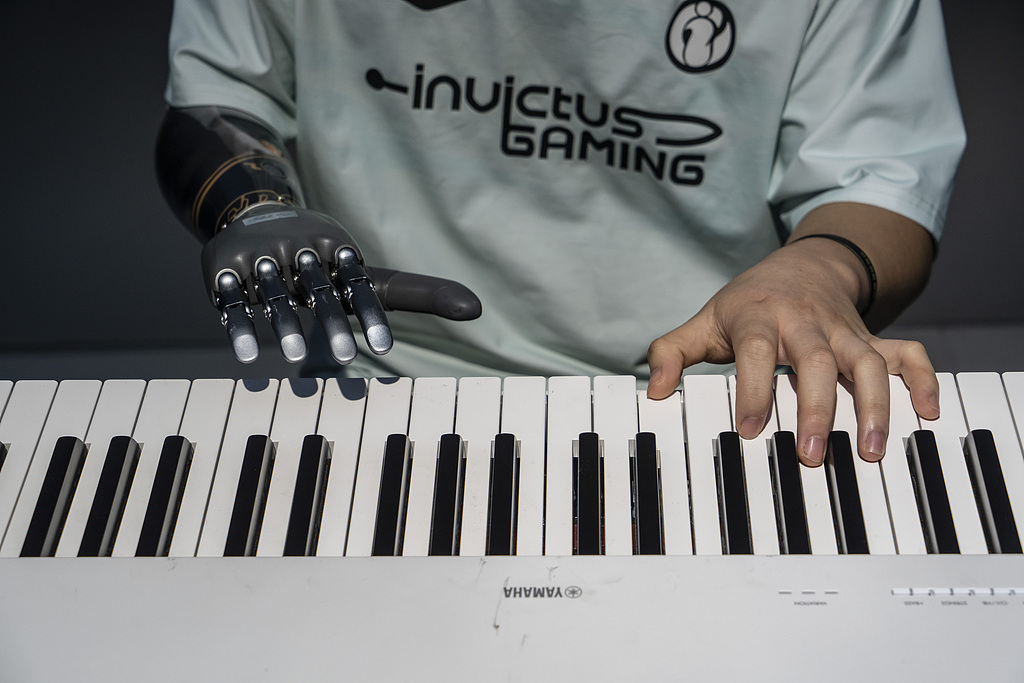 An employee with a bionic hand demonstrates playing a keyboard at the BrainCo headquarters in Hangzhou, Zhejiang Province, China, June 1, 2026. /VCG