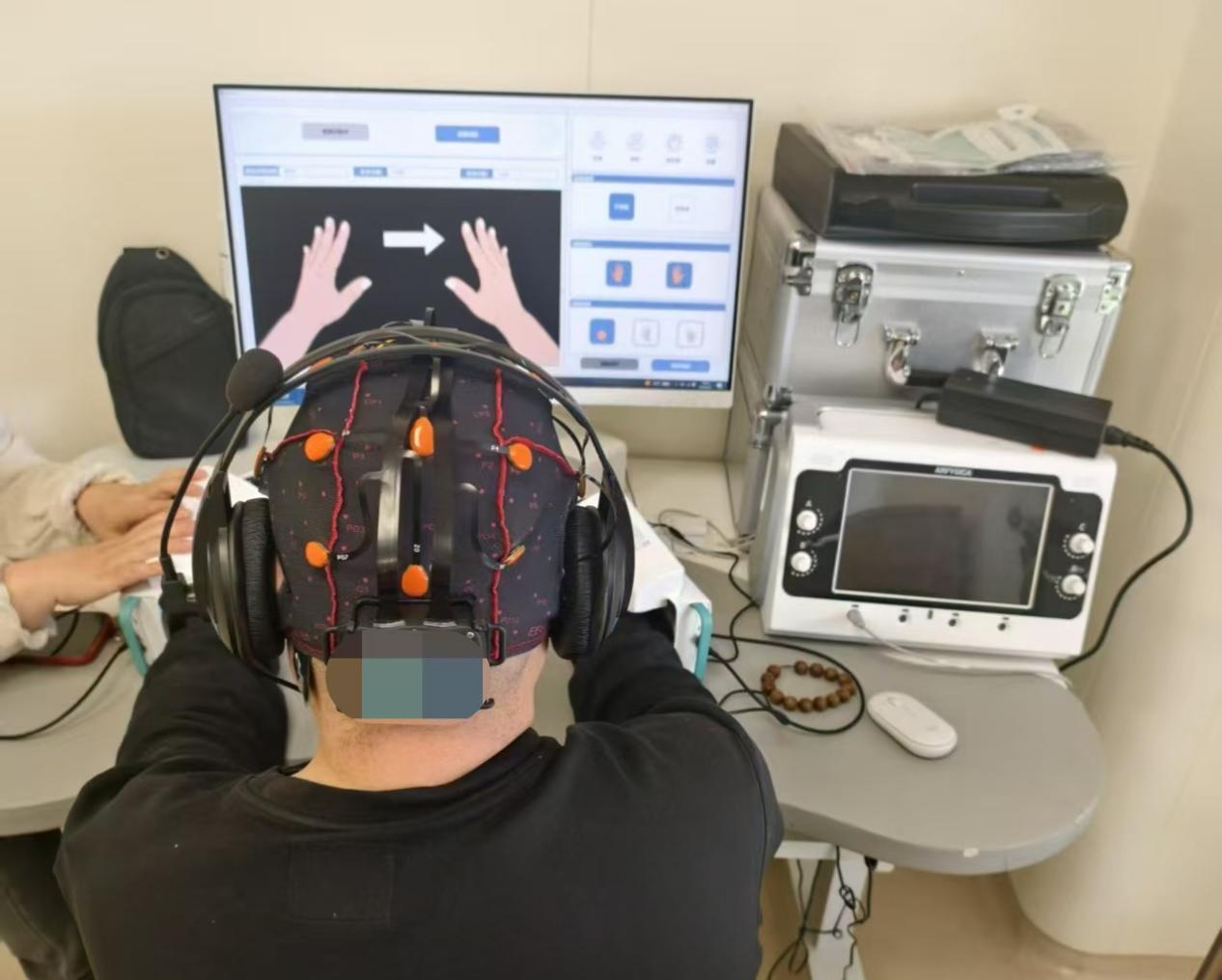A patient performs hand movements using a brain-computer interface. /CMG