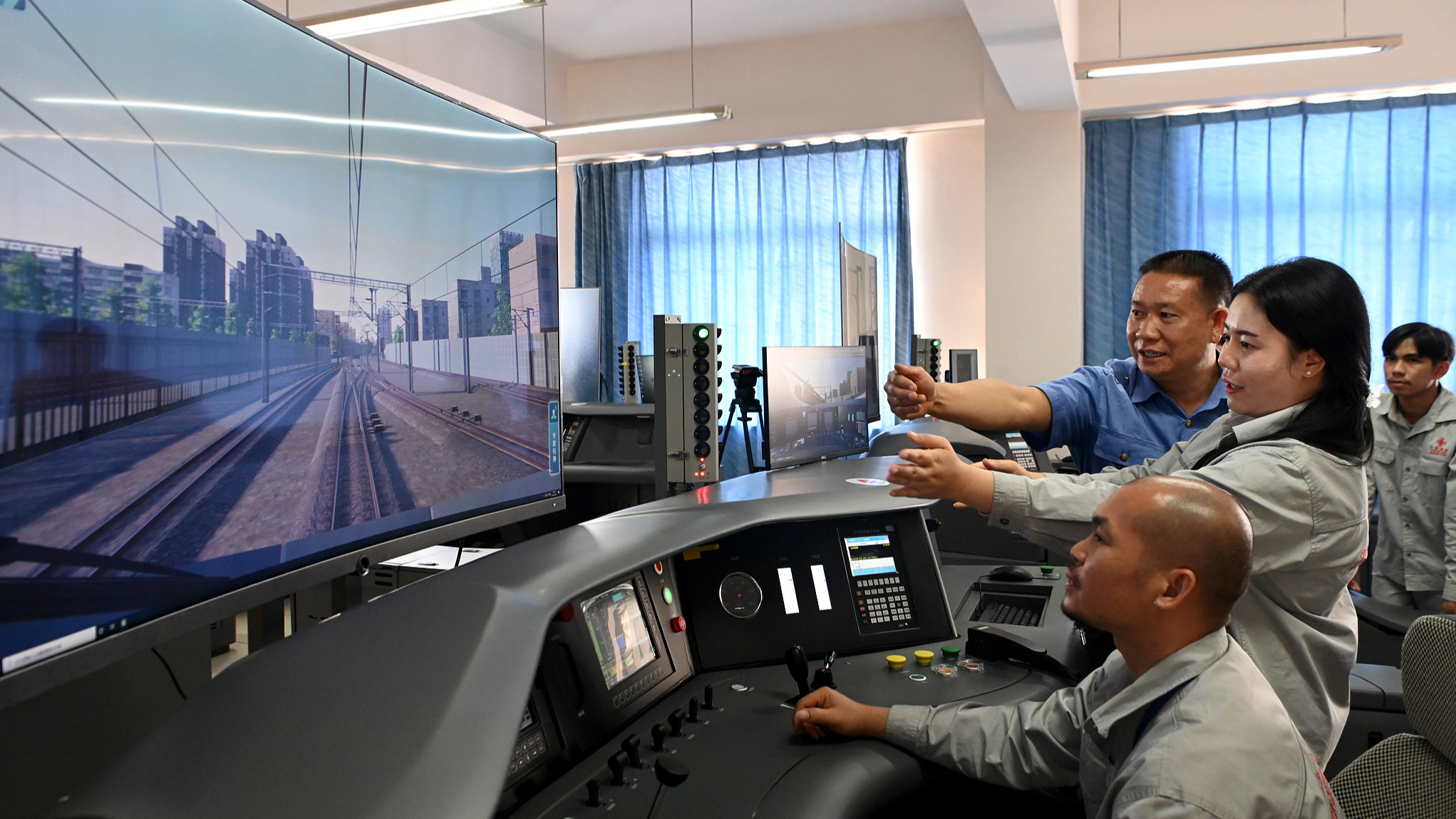Lao railway trainees receive training in a train-driving simulator classroom in Kunming, Yunnan Province, China, June 28, 2022. /VCG