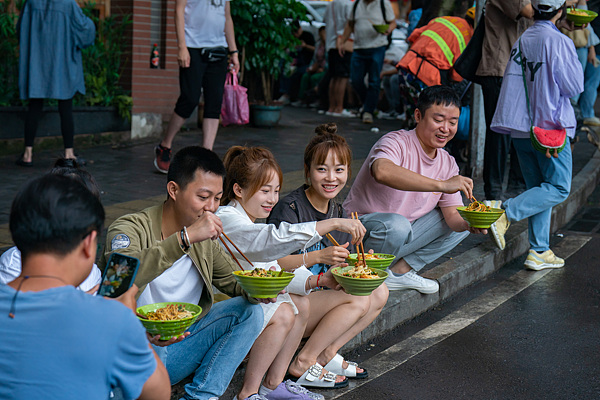 Tourists eat Chongqing spicy noodle in Yuzhong District, Chongqing, September 23, 2023. /VCG