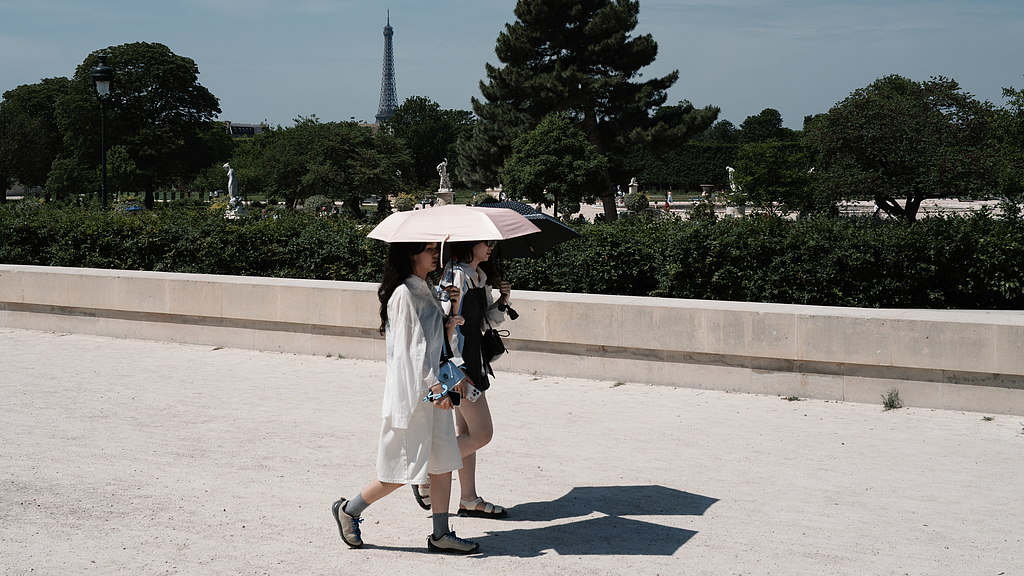 Two people shield themselves from the sun under an umbrella in Tuileries Garden in Paris, France, May 28, 2026. /VCG