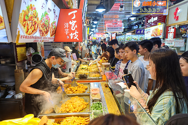 Customers wait for their orders on a street lined with eateries serving local specialties, Chongqing, China, June 1, 2026. /VCG