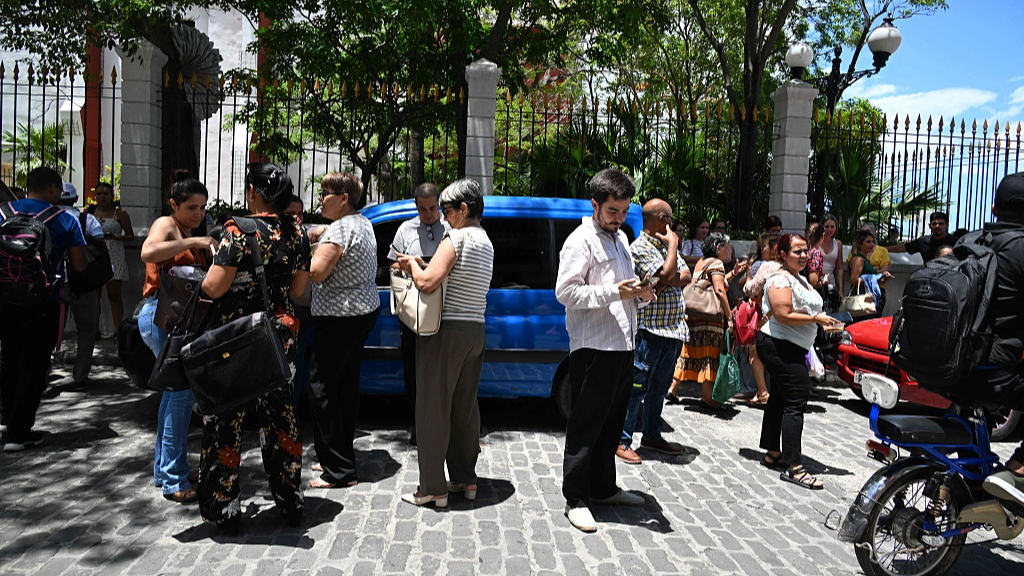 Workers check their cell phones after a tremor caused by an earthquake, Havana, Cuba, June 8, 2026. /VCG