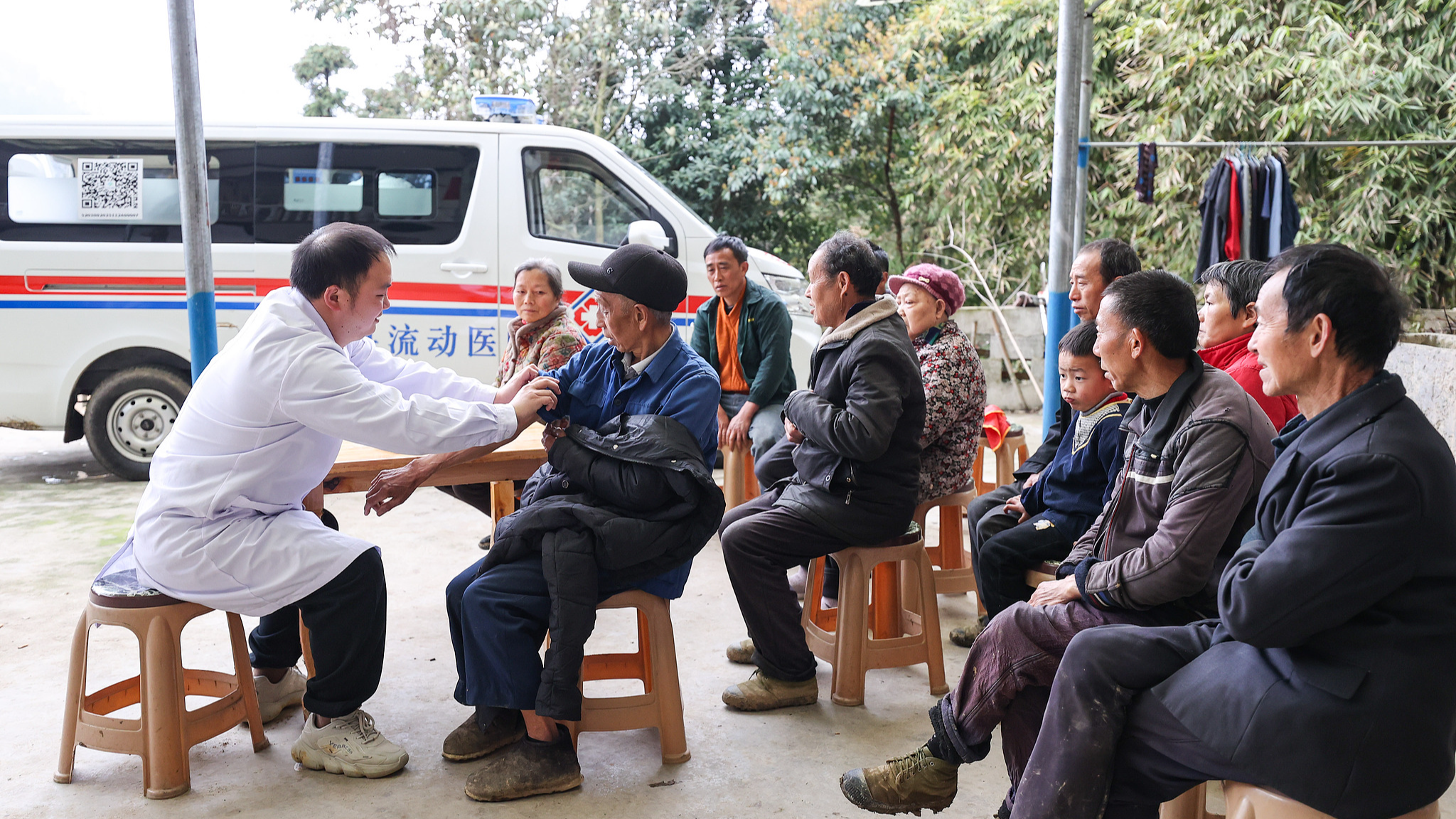 A doctor from the mobile hospital of the Heba Subdistrict Health Center in Fenggang County, Zunyi City, southwest China's Guizhou Province, measures the villagers' blood pressure, March 21, 2026. /VCG