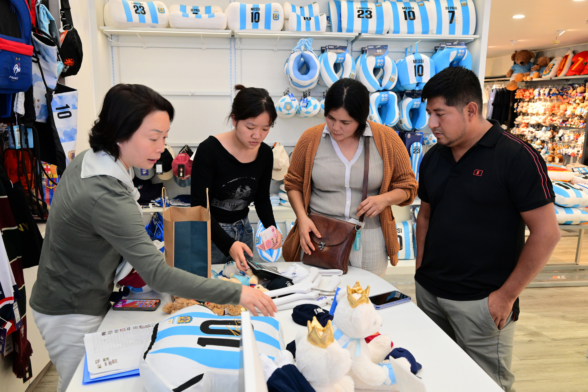 A foreign businessman from Mexico seen purchasing officially authorized products related to the World Cup of the United States, Canada, and Mexico, such as football-themed clothing and fan accessories, at the International Trade Fair in Yiwu, Zhejiang Province, June 10, 2026. /VCG