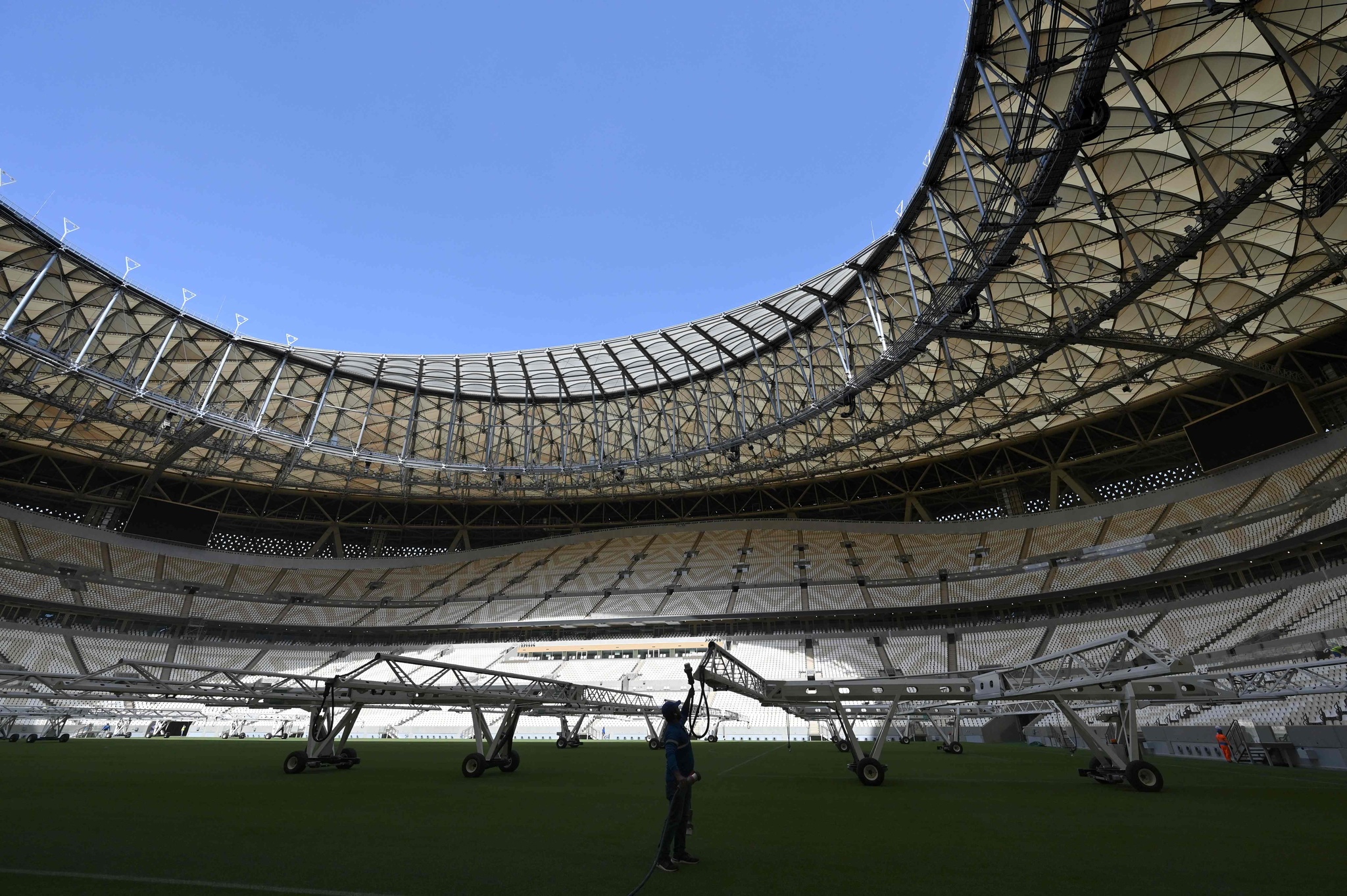 A man works on the pitch of the Lusail Stadium, the 80,000-capacity venue which hosted the 2022 FIFA World Cup final, on the outskirts of Qatar's capital Doha, March 28, 2022. /VCG