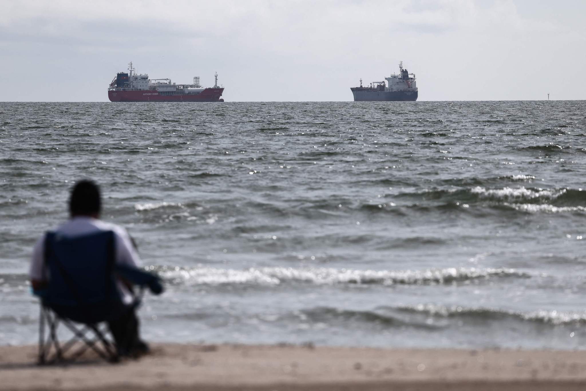 A man sitting on a chair watches the Chemical Tanker CORAL STAR (L) and the Oil and Chemical Tanker HAFNIA MAGELLAN waiting in the Grand Port Maritime de Marseille-Fos in Fos-sur-Mer, off the Mediterranean coast of southern France, March 11, 2026. /VCG
