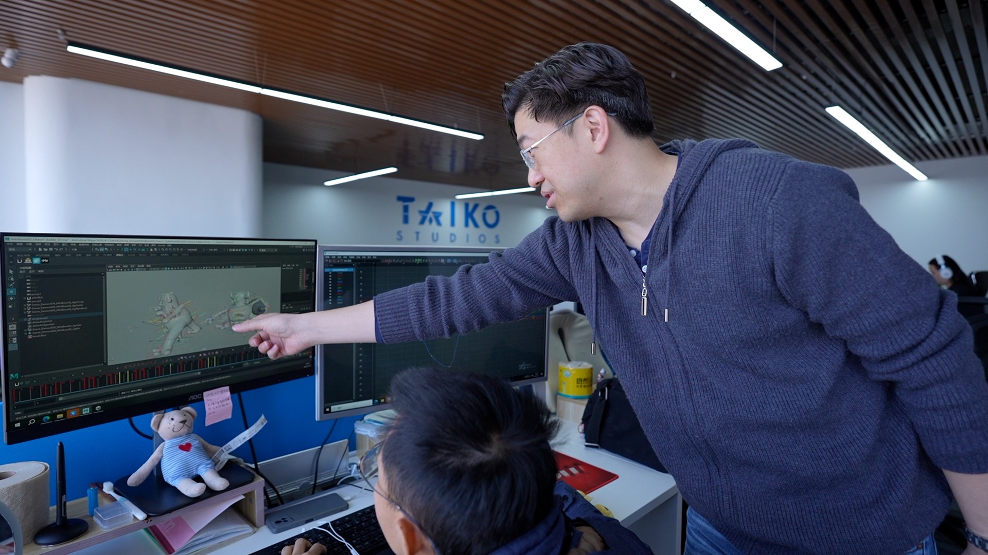 Zhang Shaofu discusses a character's motion with an employee. /CGTN