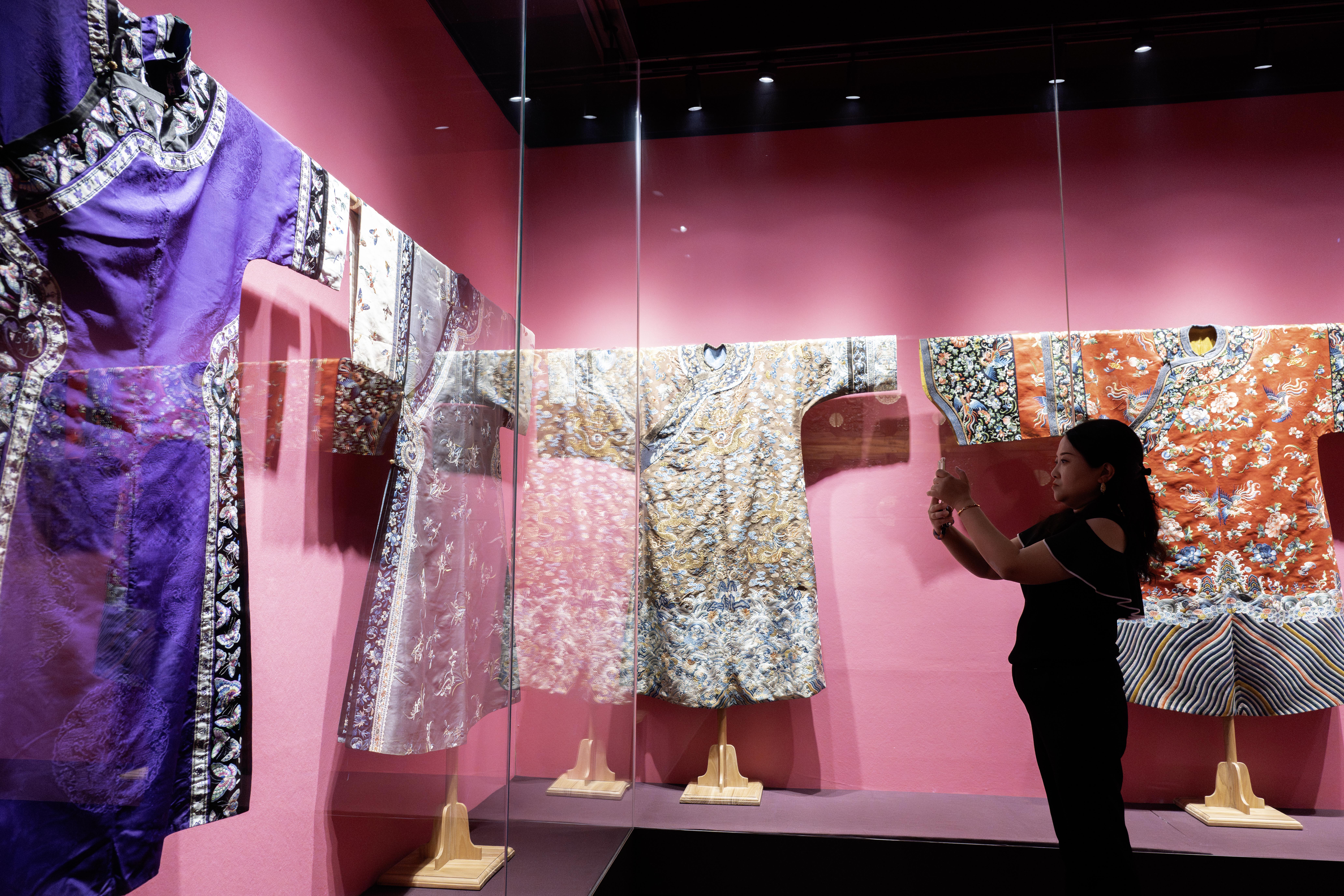 A visitor takes pictures at the exhibition hall of Chaoyang Jingxiu Cultural Inheritance Institute in Beijing on June 12, 2026. /CGTN