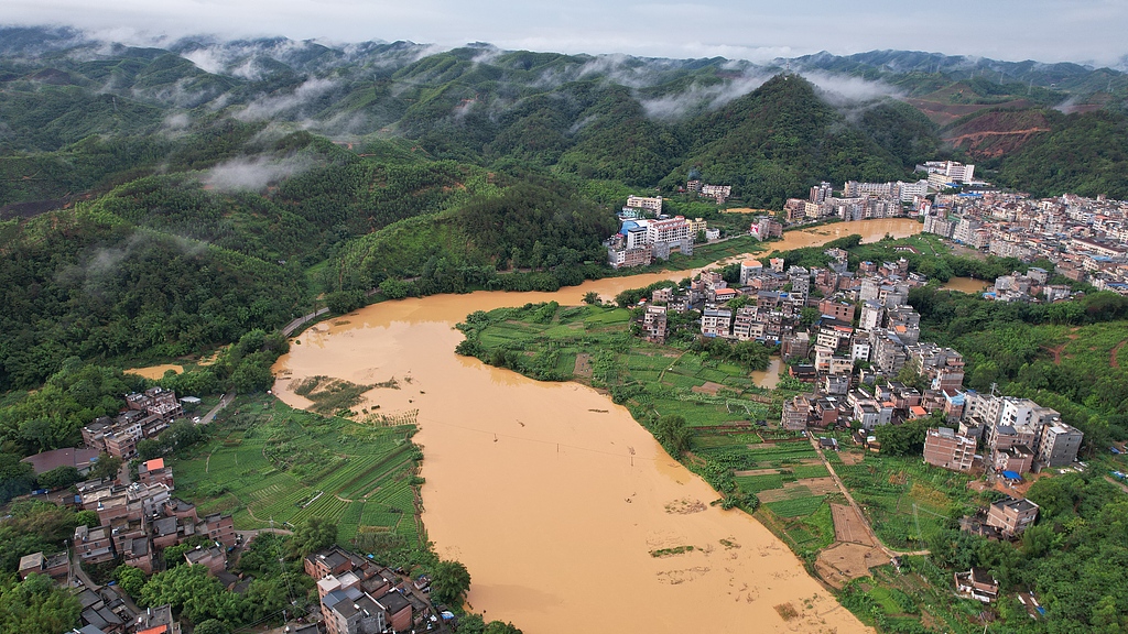 The rising river water overflows the embankment in Wangfu Town, Guangxi, south China's Guangxi Zhuang Autonomous Region, June 15, 2026. /VCG
