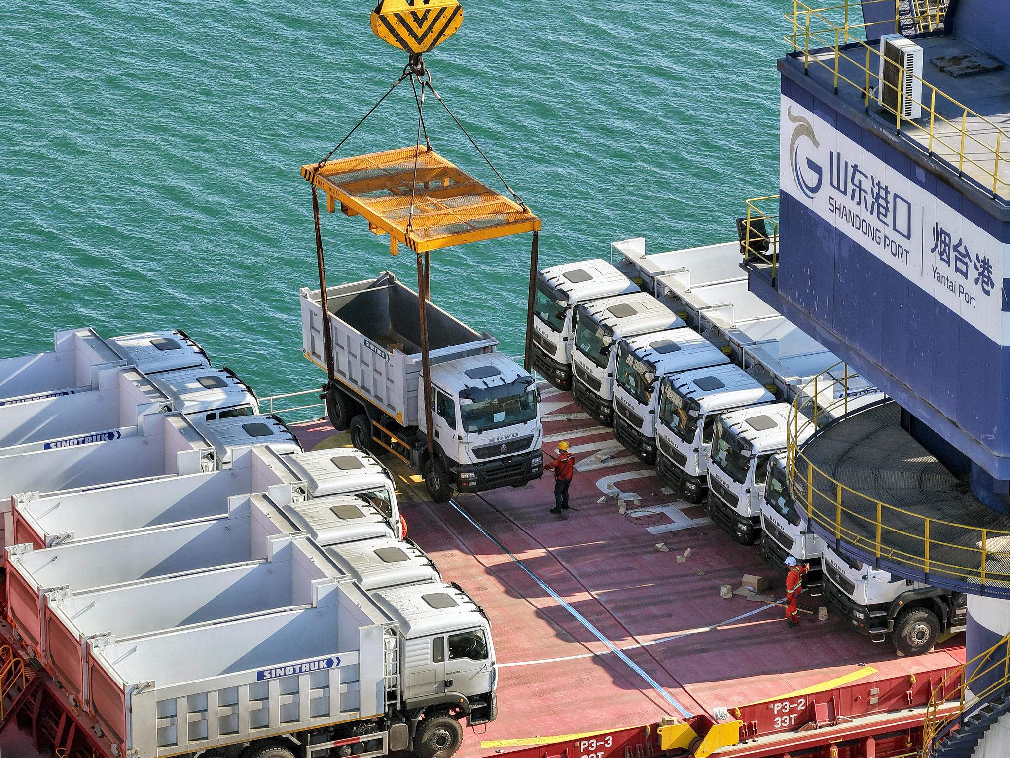 Domestically produced trucks destined for Tanzania are loaded onto a China-Africa liner at the Yantai Port of Shandong Province, China,  Jun 7, 2022. /VCG 