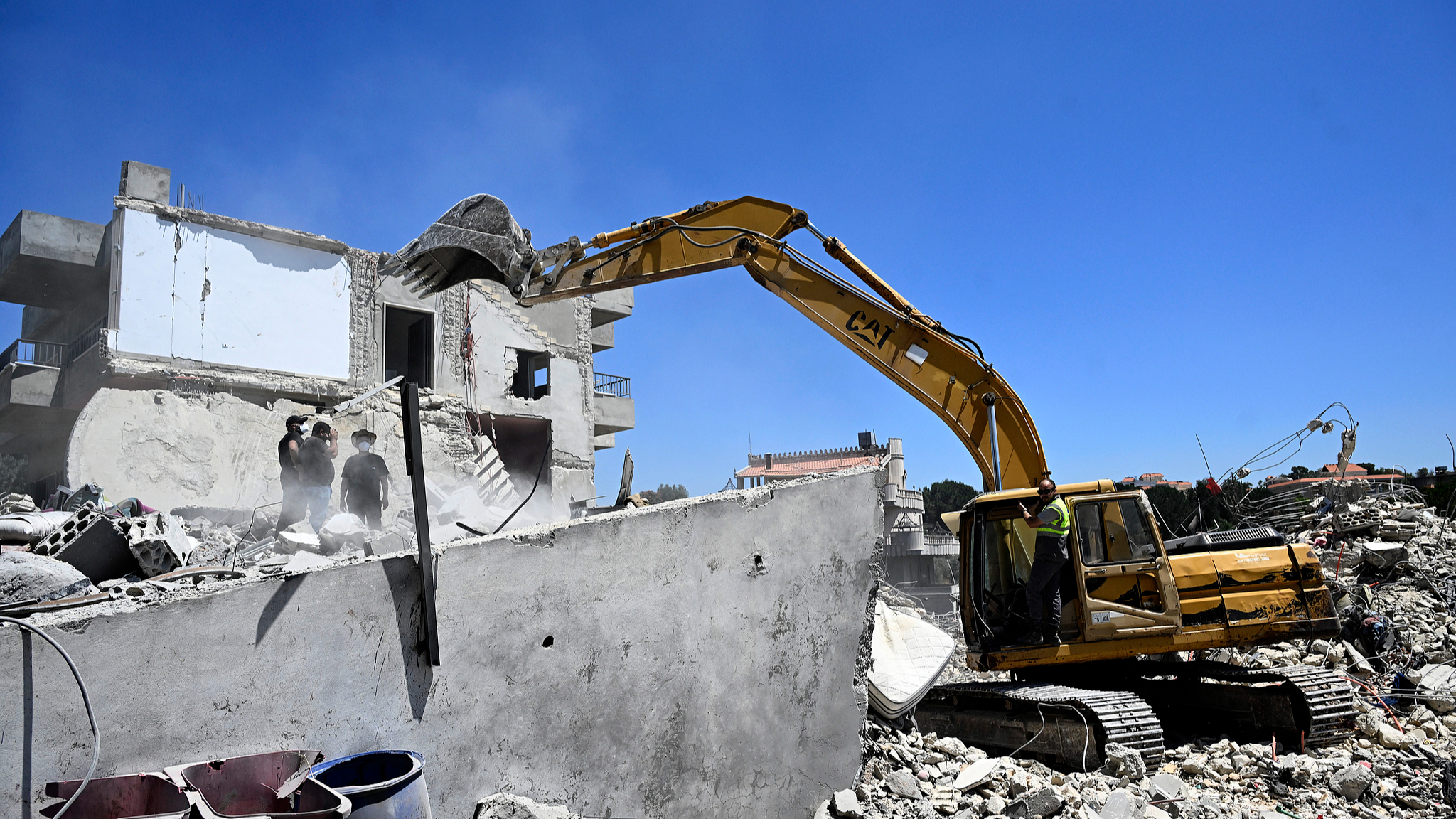 Residents who returned to their village use an excavator to search for missing people under the rubble of a destroyed building in the village of Touline, southern Lebanon, June 16, 2026. / VCG