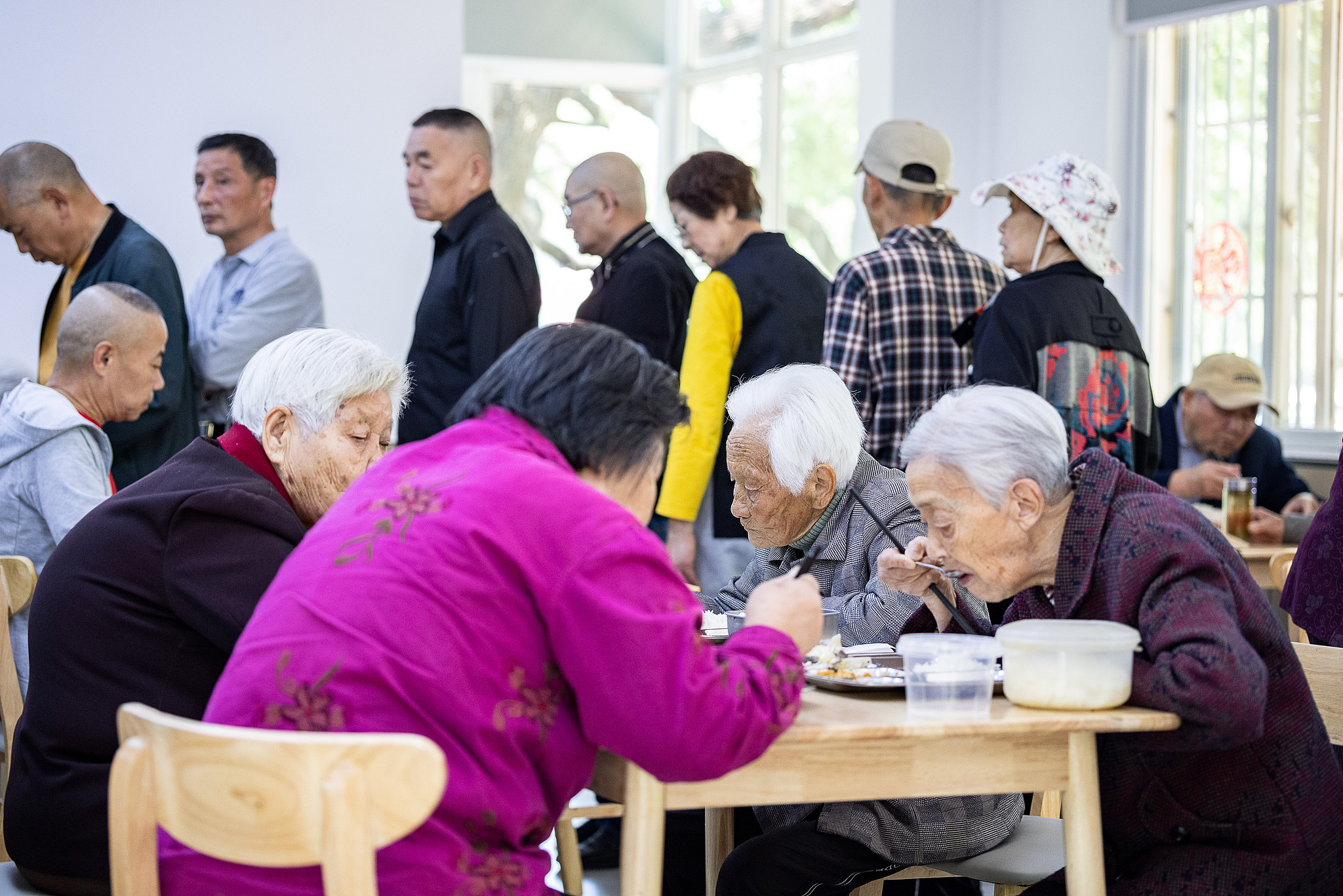 Elderly people eat at a community canteen in Huzhou, Zhejiang Province. /VCG