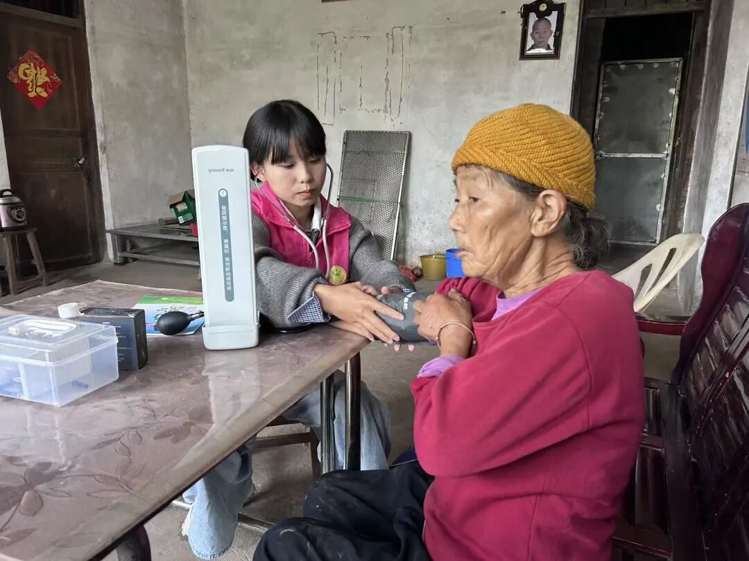 Xiong Yuanyuan, a CPC member and village doctor in Guanyang County, south China's Guangxi Zhuang Autonomous Region, measures a resident's blood pressure during a routine health checkup. /Guanyang County Health Bureau