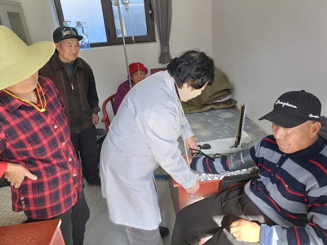 Jin Huaihua measures a villager's blood pressure. /Beijing Municipal People's Government