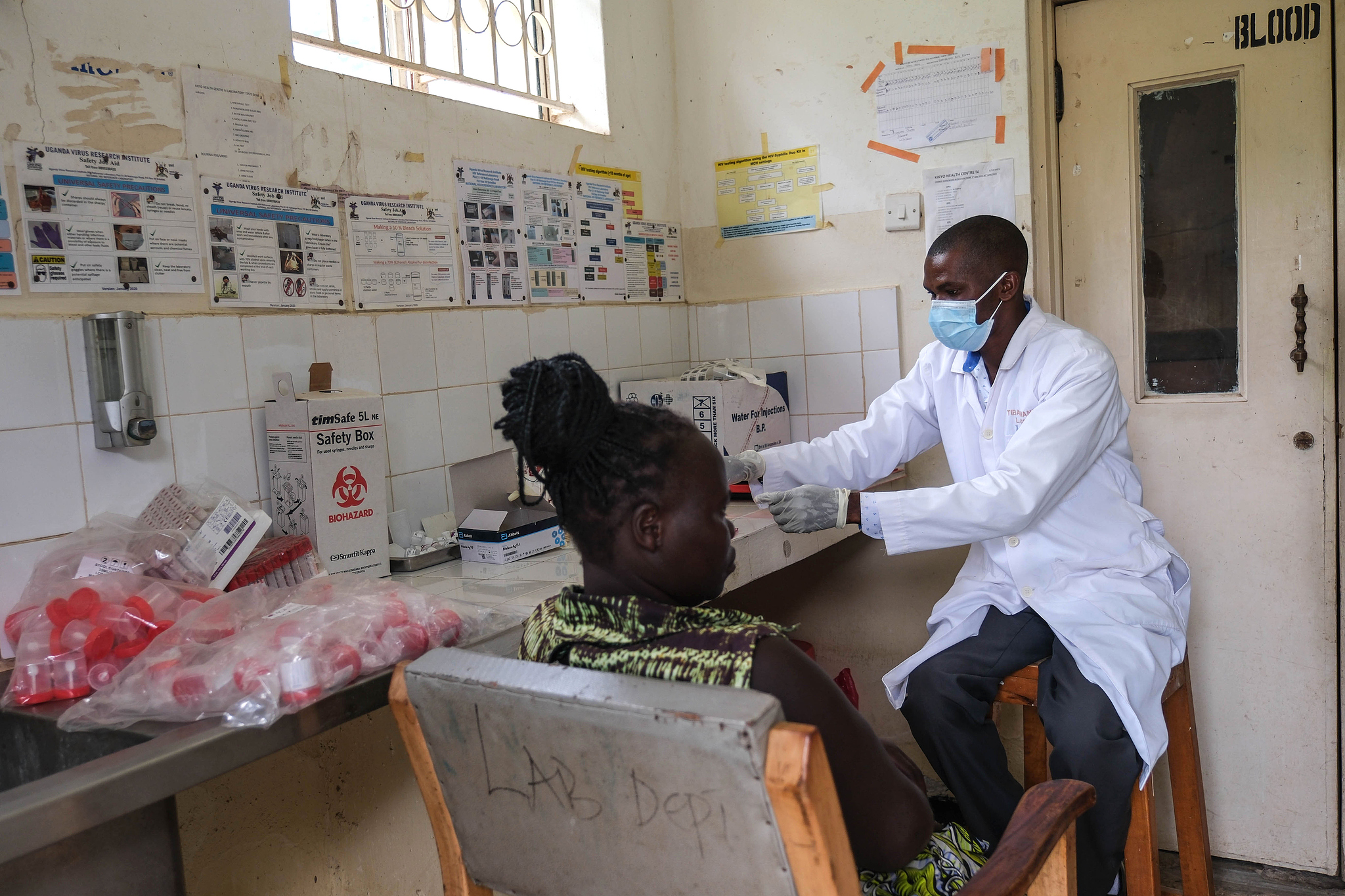 A laboratory technician works with a patient at Kikyo Health Centre IV in Kikyo Trading village, Bundibugyo District, Uganda, June 3, 2026. /VCG