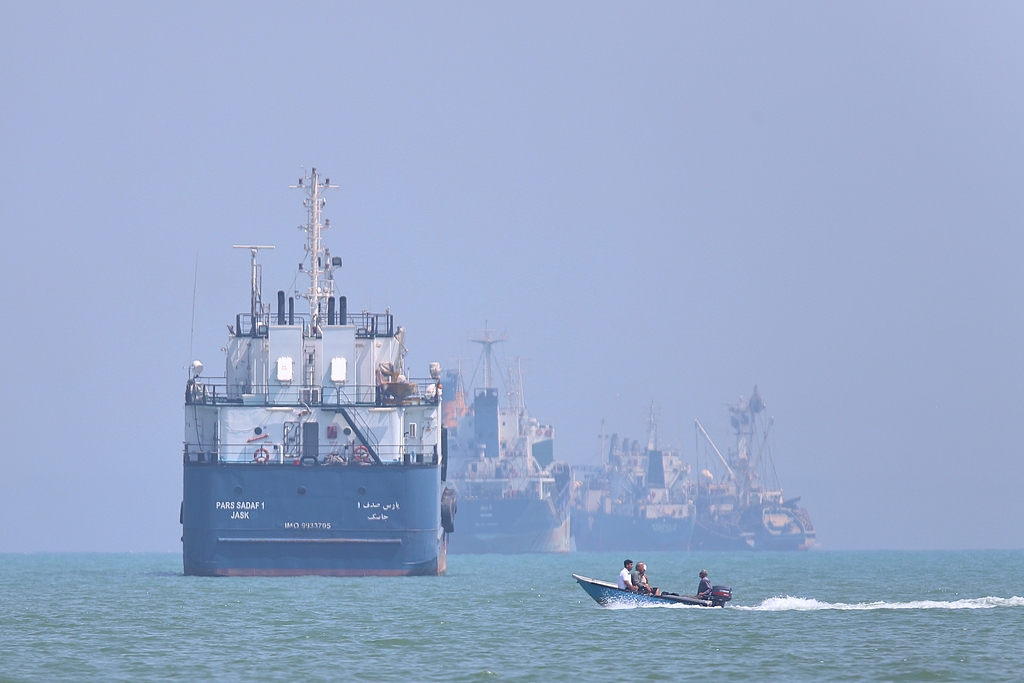 A small motorboat passes anchored vessels in the Strait of Hormuz off Bandar Abbas, Iran, June 11, 2026. /VCG