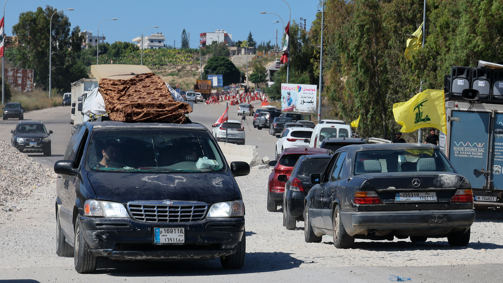 Lebanese people drive vehicles loaded with mattresses as they return to Beirut after Israeli airstrikes targeted villages near Qasmiyeh Bridge in southern Lebanon, June 19, 2026. /VCG