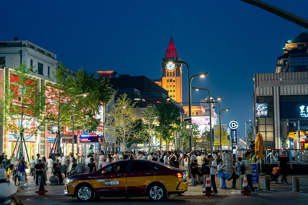 Tourists and local residents throng the streets of Beijing after dark during the Dragon Boat Festival holiday in Beijing, China, June 18, 2026. / VCG