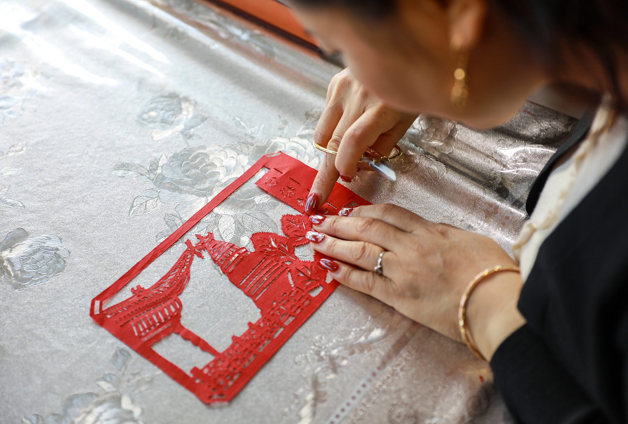 Lei Xia, head of a service center for people with disabilities in Jinta County, Gansu Province, is also a leading local paper-cutting inheritor. She teaches paper-cutting skills to trainees with disabilities. /VCG