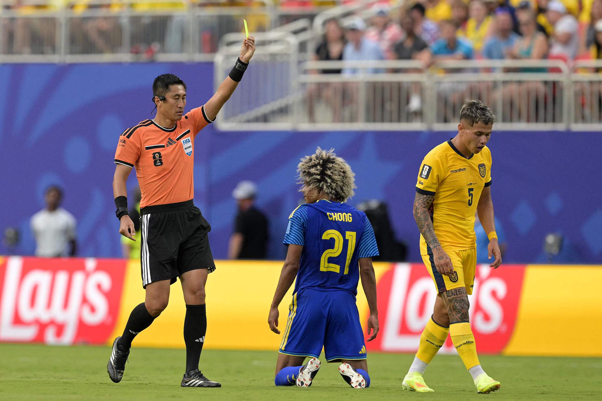 Referee Ma Ning (L) shows a yellow card to midfielder Tahith Chong (#21) during Curacao's match against Ecuador in Group E of the 2026 FIFA World Cup in Kansas City, Missouri, June 20, 2026. /VCG