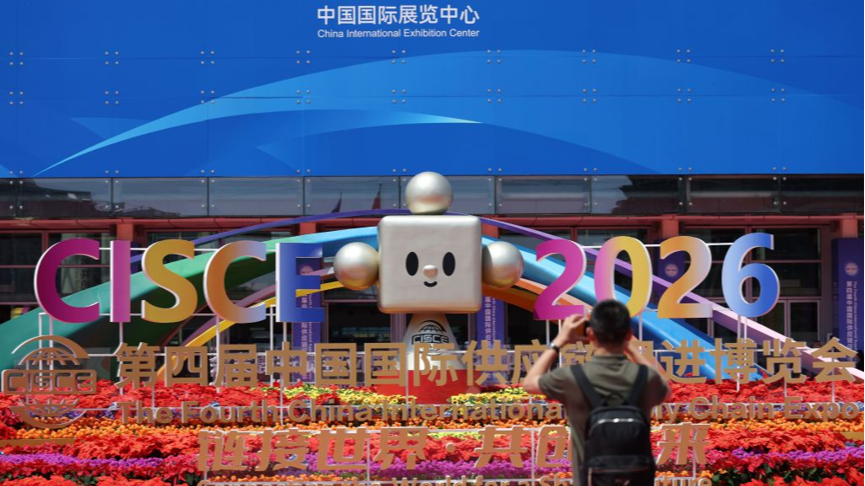A man takes photos outside the venue of the Fourth China International Supply Chain Expo in Beijing, capital of China, June 22, 2026. /Xinhua