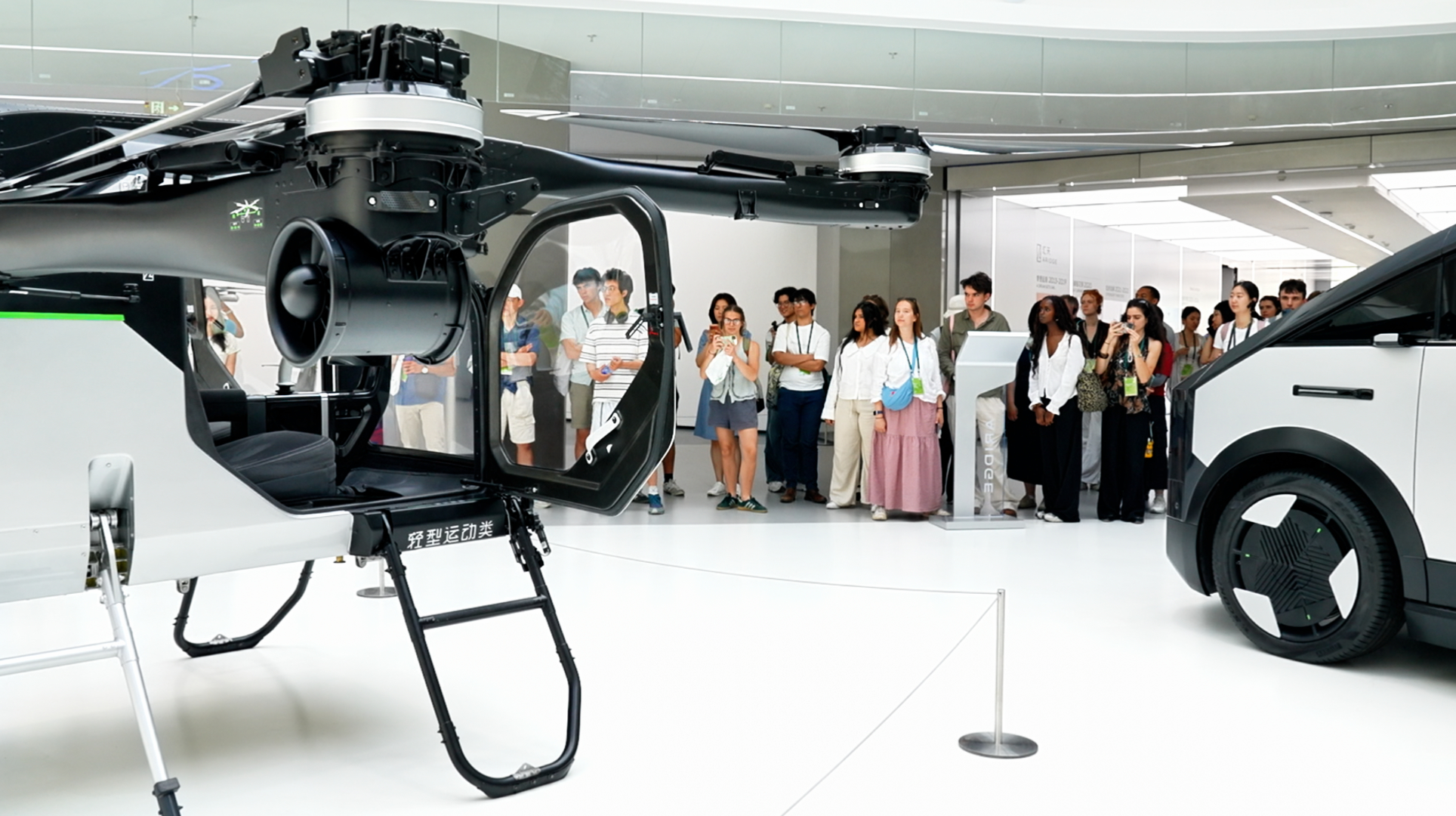 Students from universities including Oxford, Cambridge and Tsinghua look at flying cars in Guangzhou, south China's Guangdong Province, on June 22, 2026. /CGTN