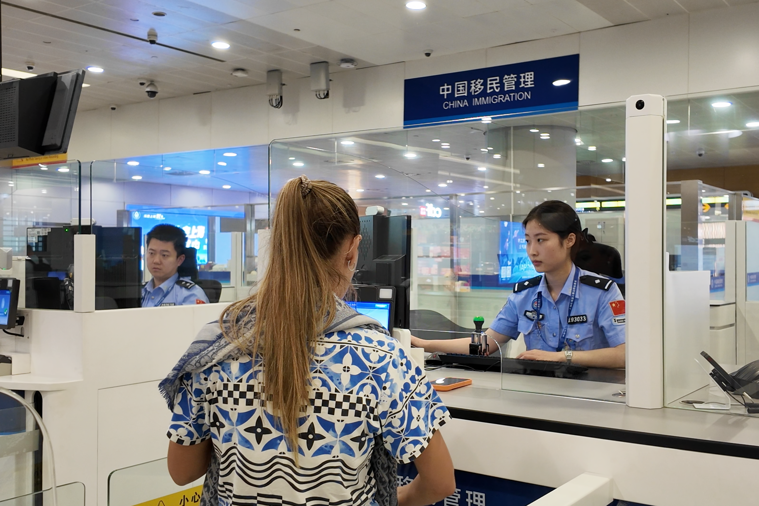 An immigration officer was processing entry and exit formalities for a traveler at Shanghai Pudong International Airport. /Shanghai General Station of Immigration Inspection