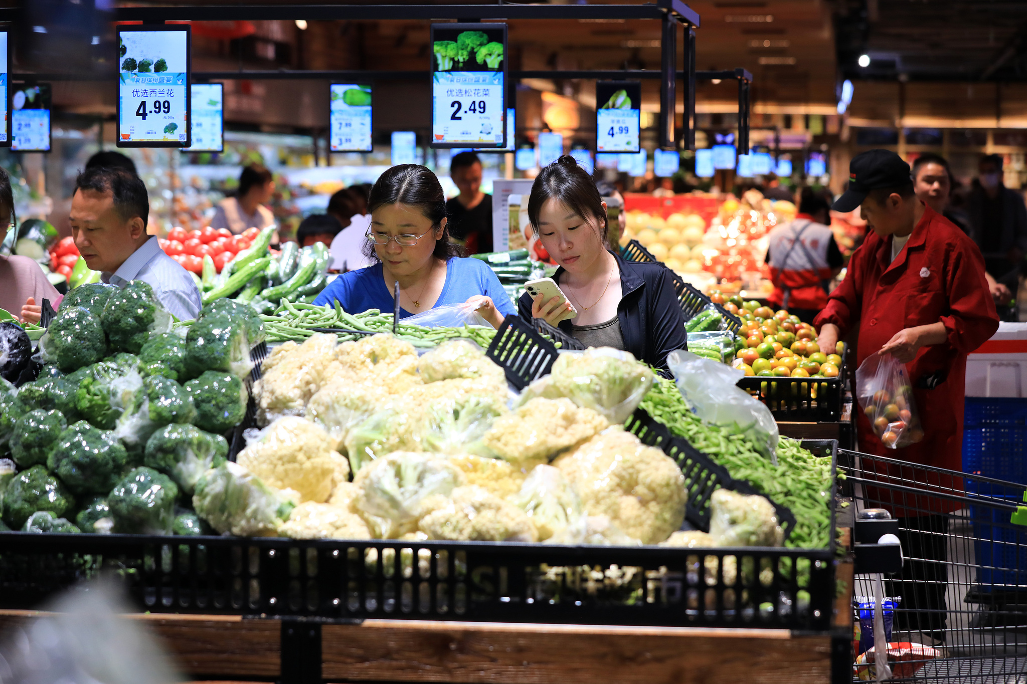 Shoppers choose fresh vegetables at a local supermarket in East China's Jiangsu province. /VCG