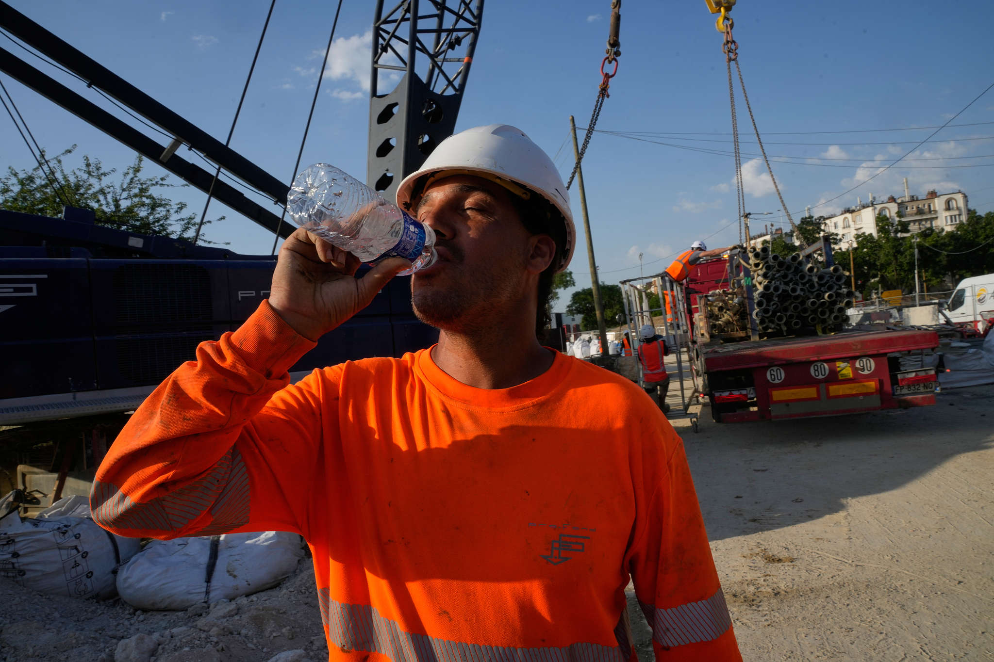 A construction worker drinks water to stay hydrated at a massive construction site as temperatures are expected to reach record highs in Paris, France, June 24, 2026. /CFP