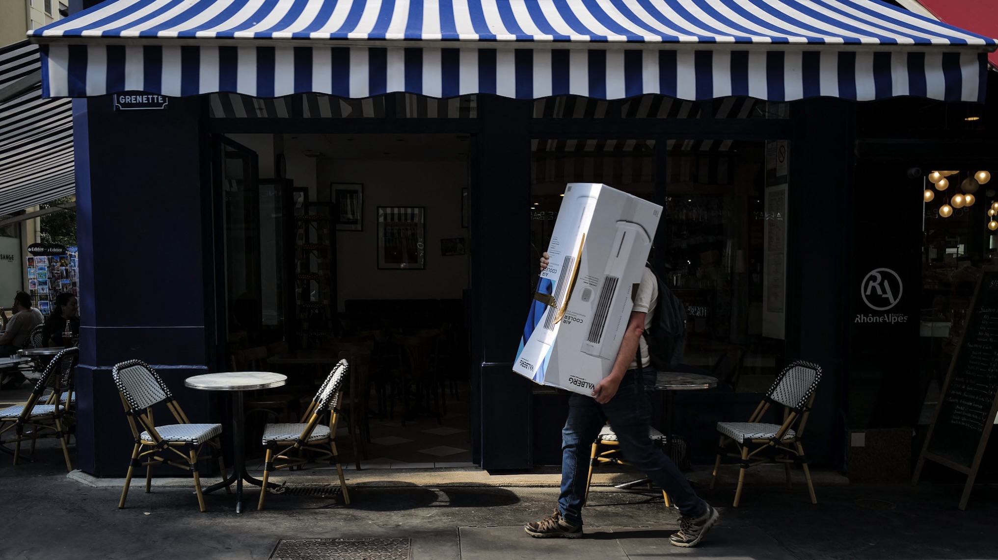 A man carries a portable fan while walking along a street during hot weather in Lyon, France, June 24, 2026. /VCG