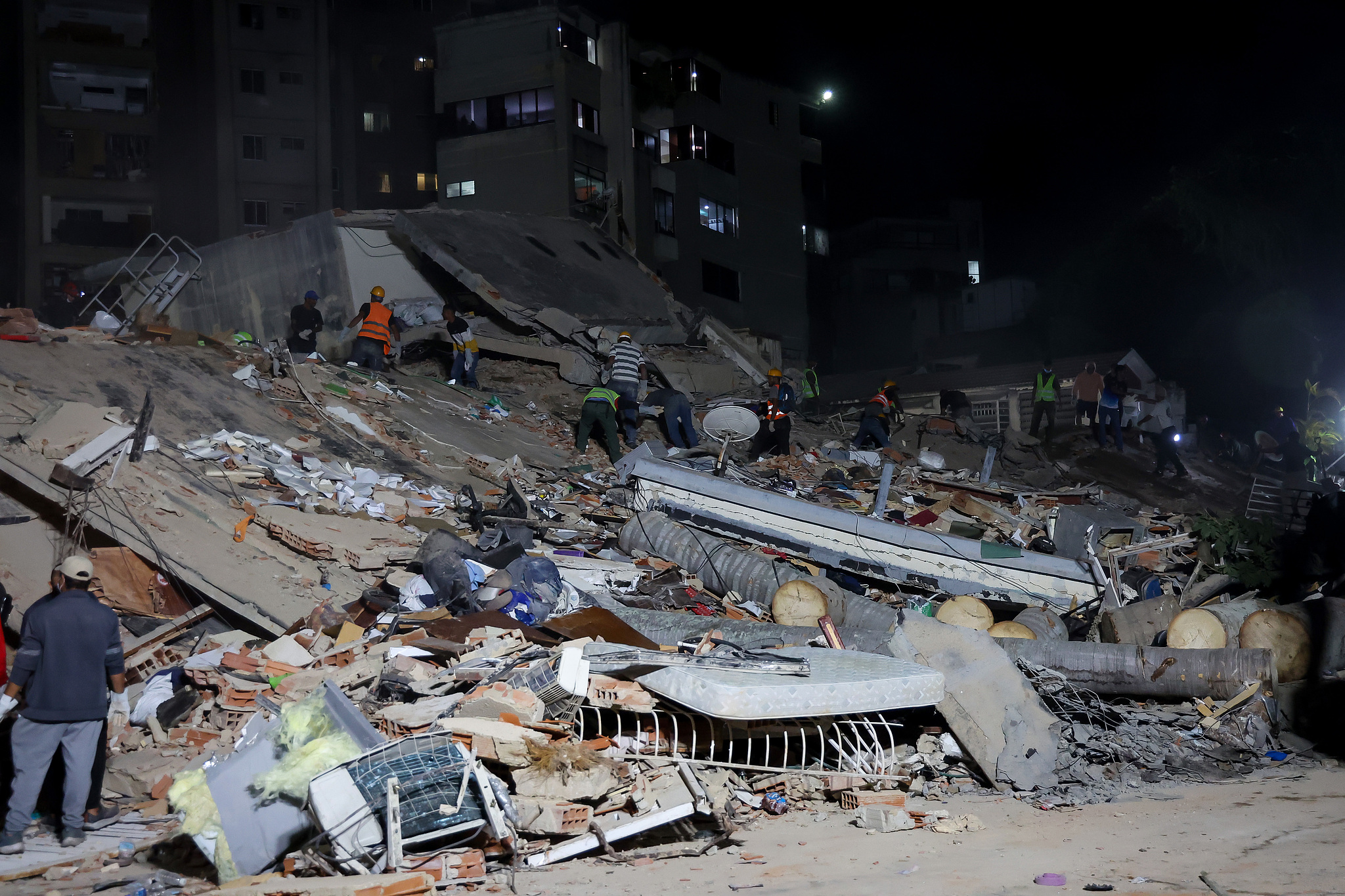 After powerful earthquakes, people and rescuers work on the debris from collapsed buildings in Caracas, Venezuela, June 24, 2026. /VCG