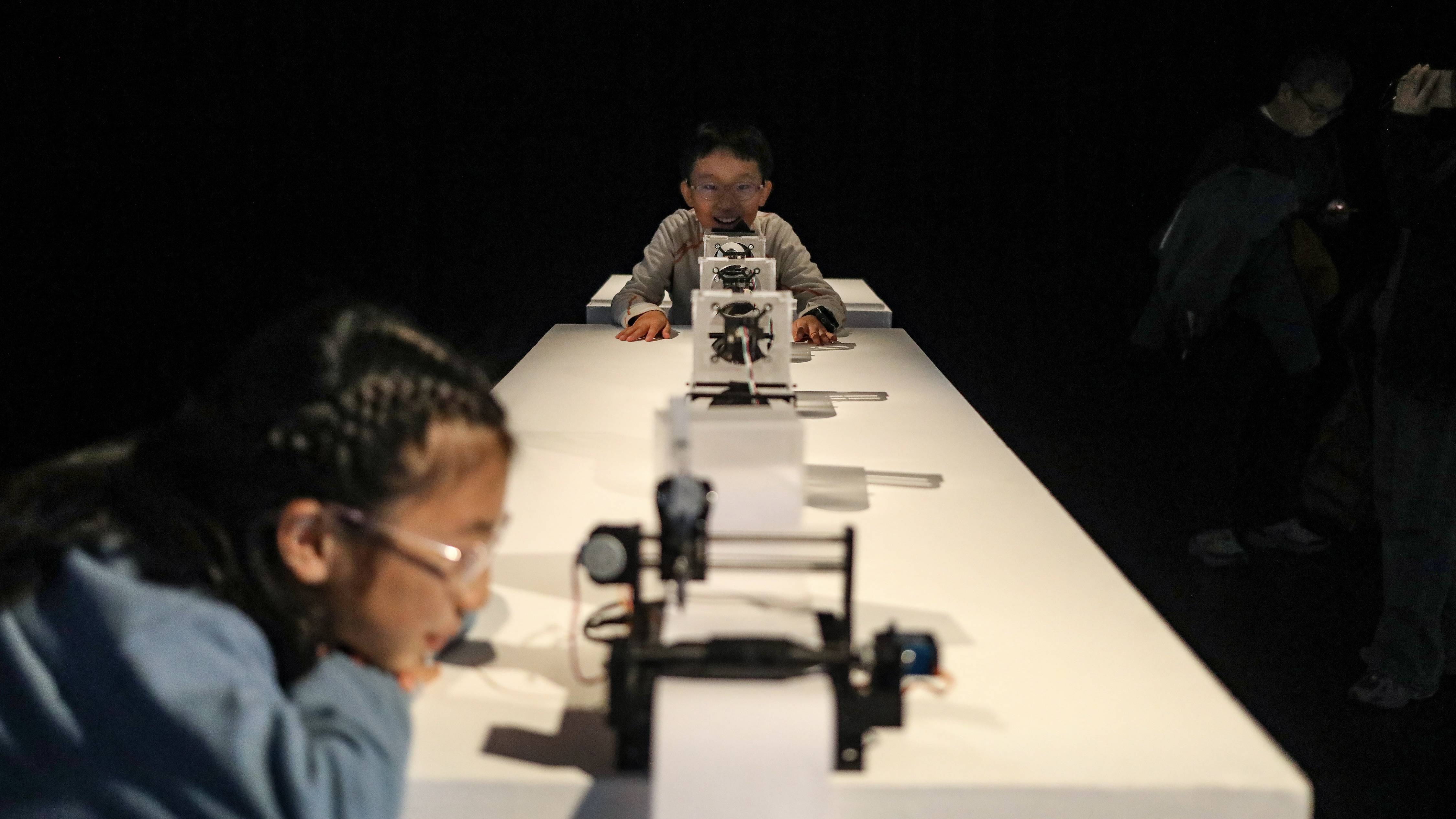 Two children look at an artwork combining robotics and artificial intelligence at the Tsinghua University Art Museum in Beijing, China, November 22, 2025. /VCG