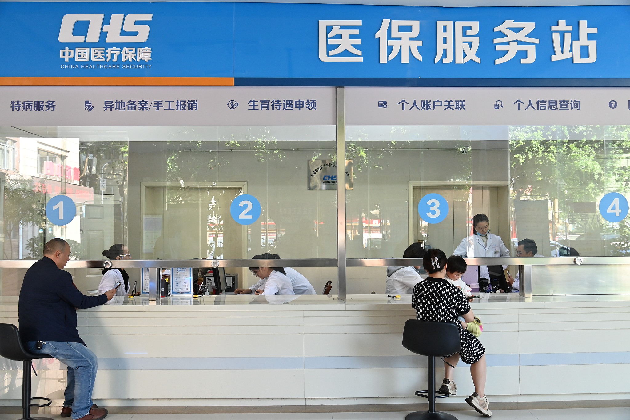 Staff members address residents' inquiries regarding medical insurance policies at a service station at a hospital in Shapingba District of Chongqing, southwest China, October 15, 2024. /CFP