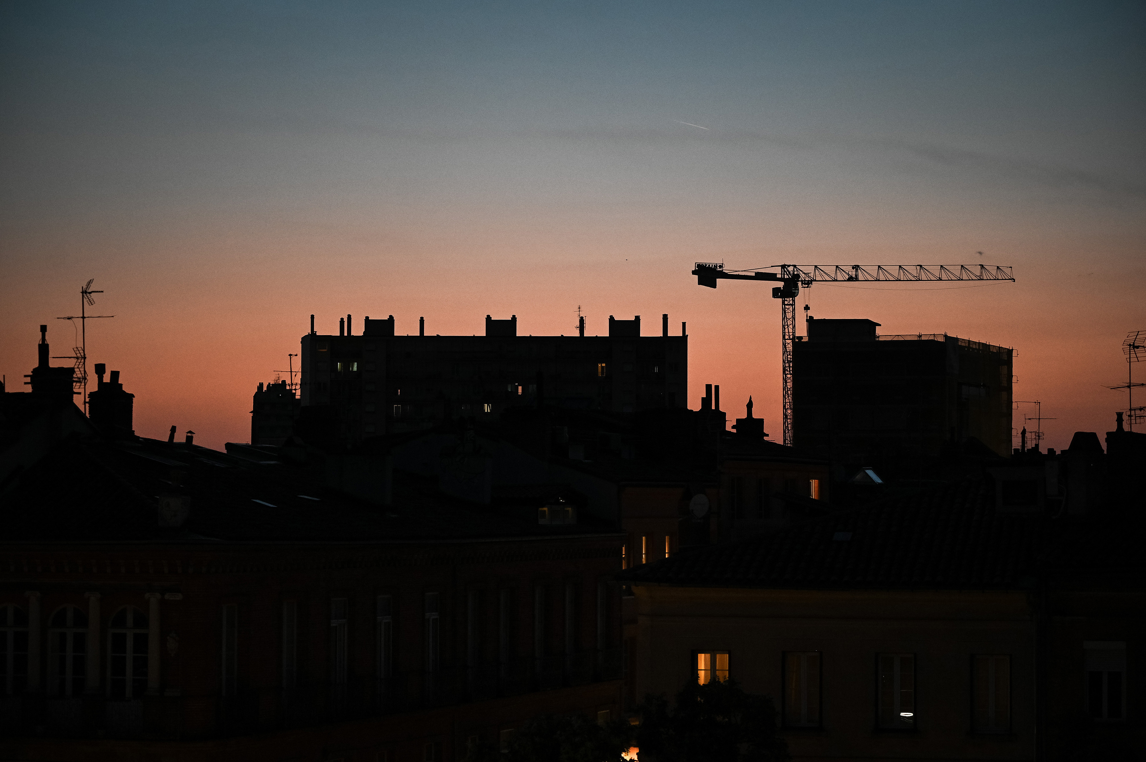 Residential buildings and a construction crane are seen at sunset during a heatwave in Toulouse, France, June 23, 2026. /VCG
