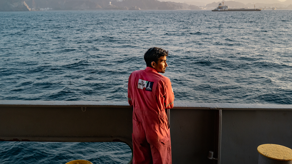 A sailor stands on a vessel anchored off the coast of Oman, June 23, 2026. /VCG