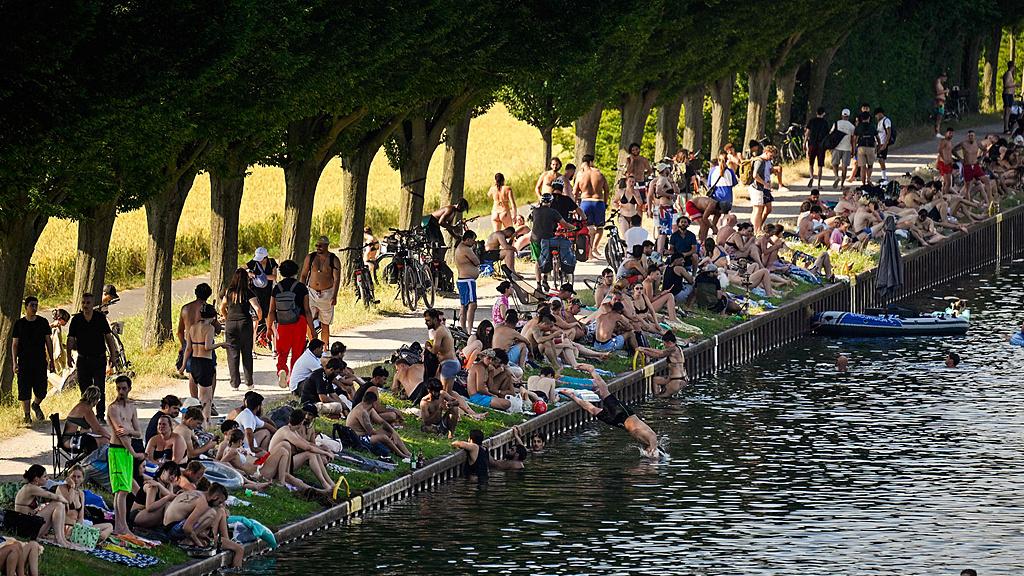People sit at the side of the Dortmund-Ems Canal in Dortmund, western Germany during a heatwave in Europe, June 26, 2026. /VCG